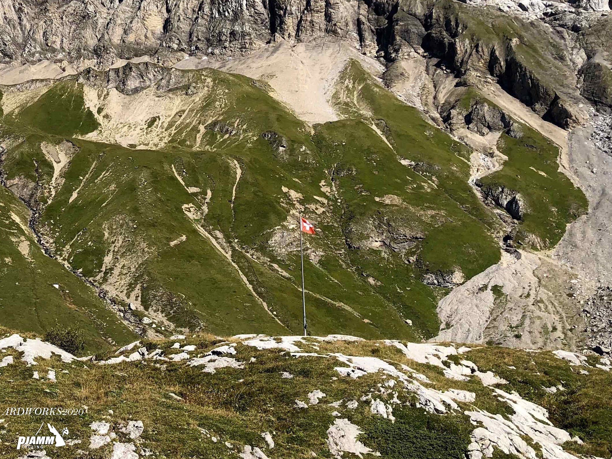 Cycling Sanetsch Pass, Switzerland - swiss flag on top of flat point on swiss alps
