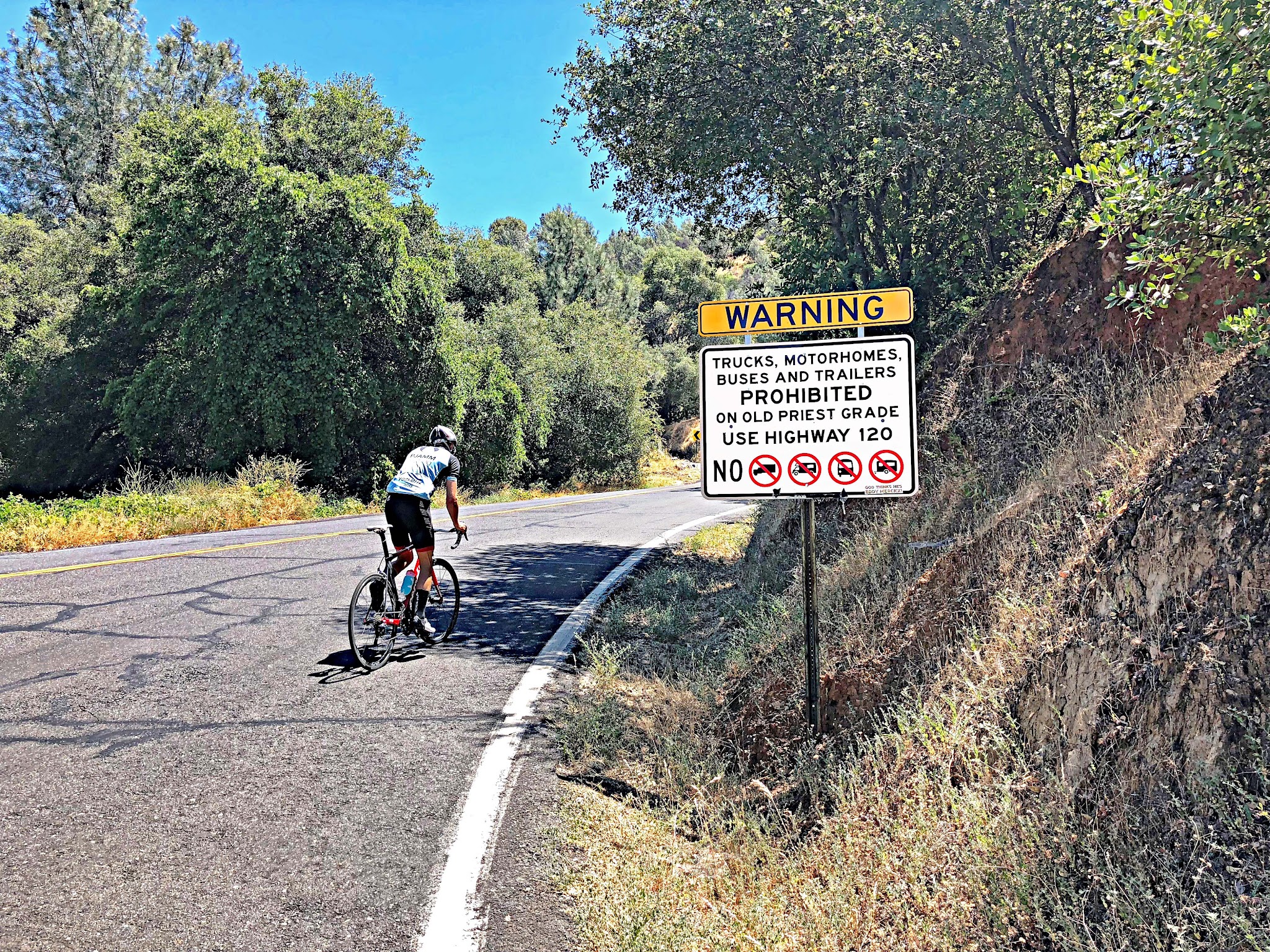 Climbing Old Priest Grade  by bike - street warning sign with cyclist
