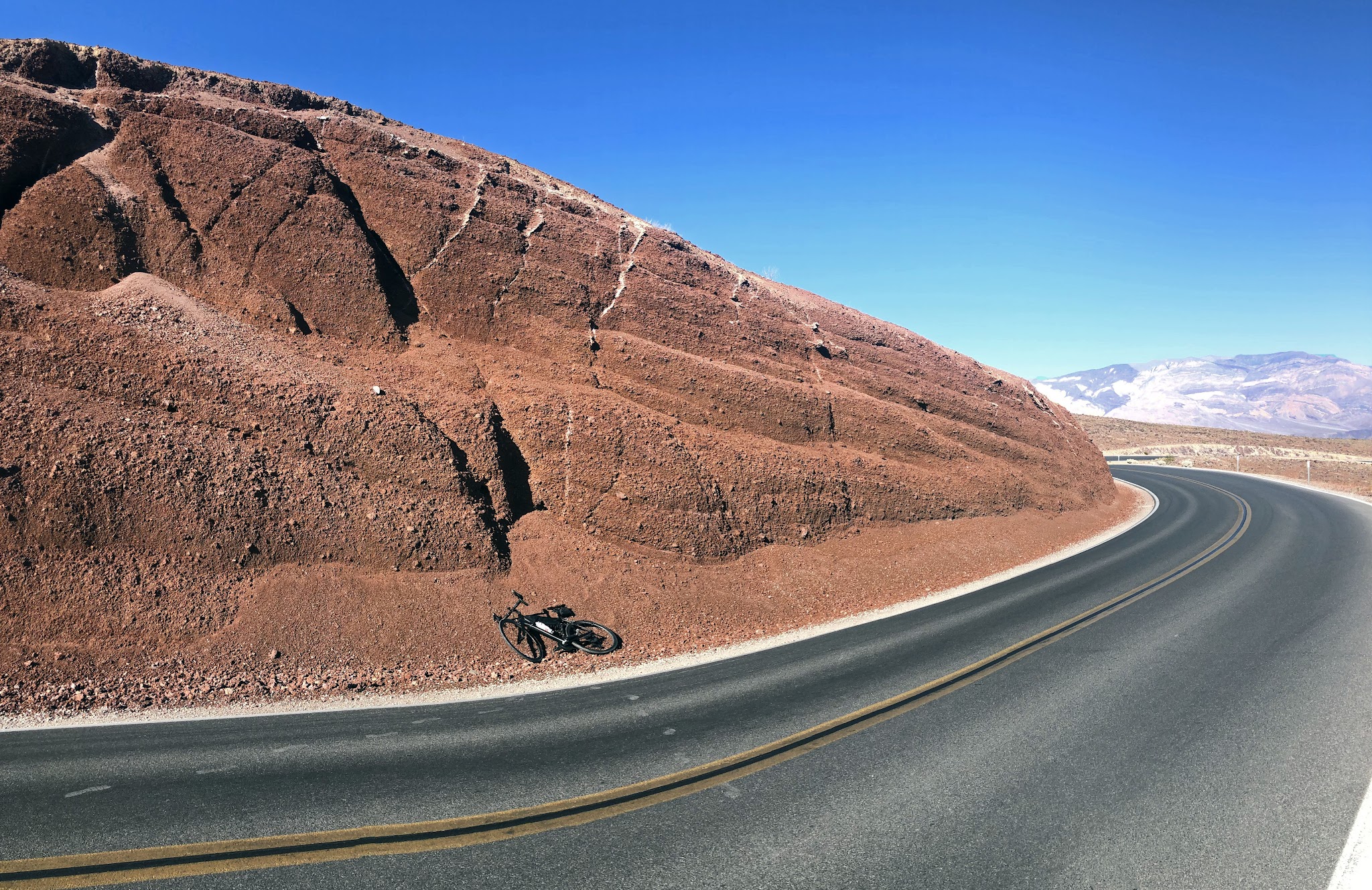 Climbing Panamint Grade by bike - bicycle leaning against red rock
