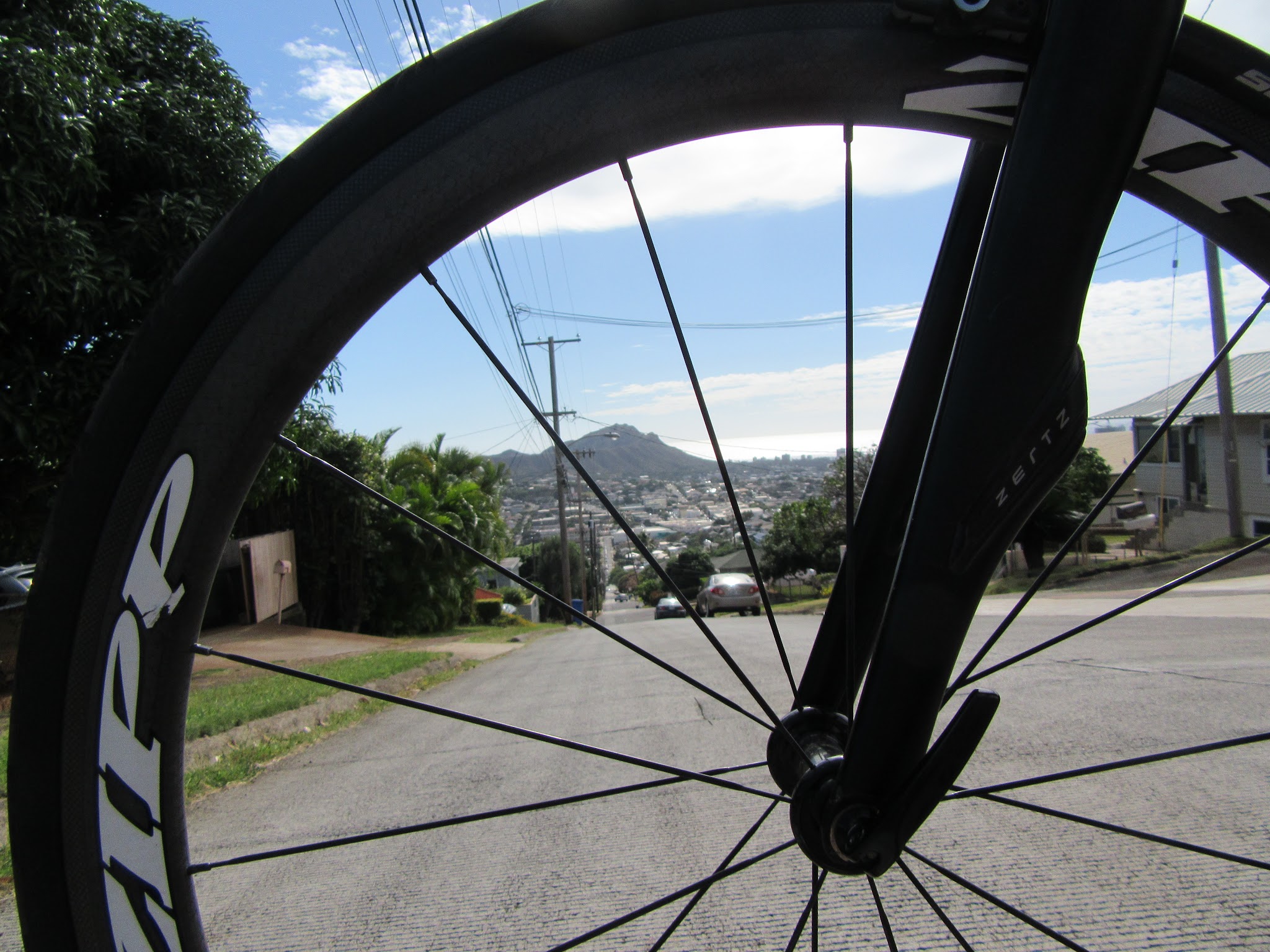 Climbing Wilhelmina Rise by bike - Diamond Head through bike wheel