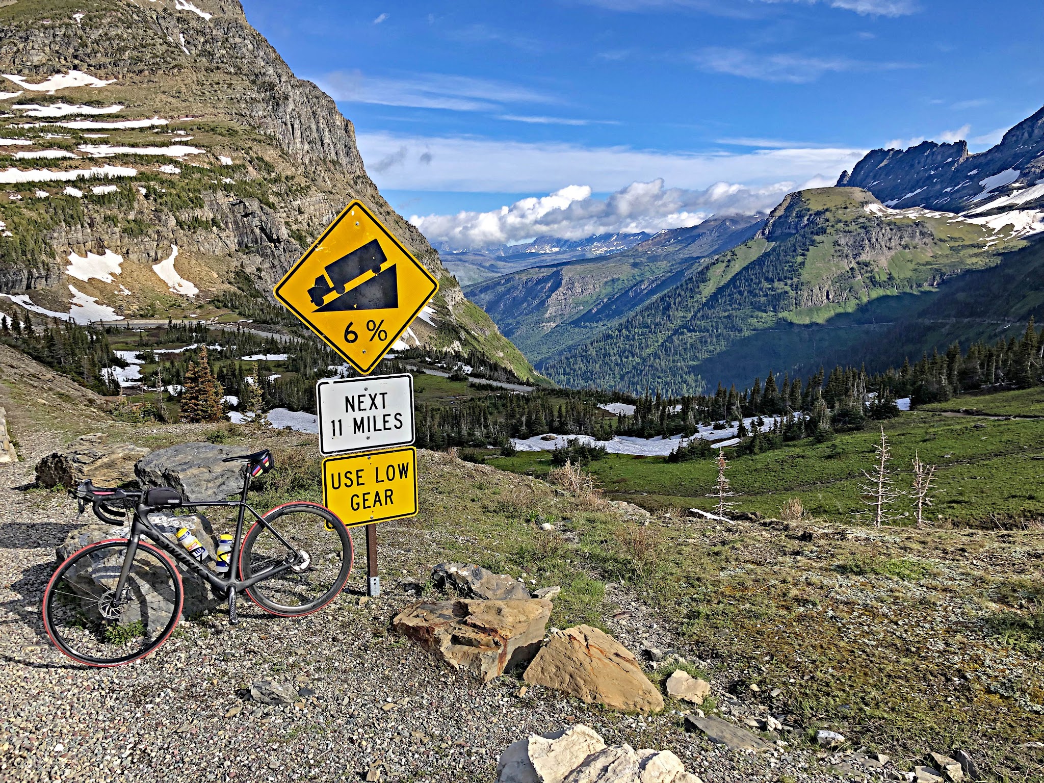 Cycling Logan Pass West, Going-to-the-Sun Road, Glacier National Park -  bike parked next to road sign for 6% grade for the next 11 miles