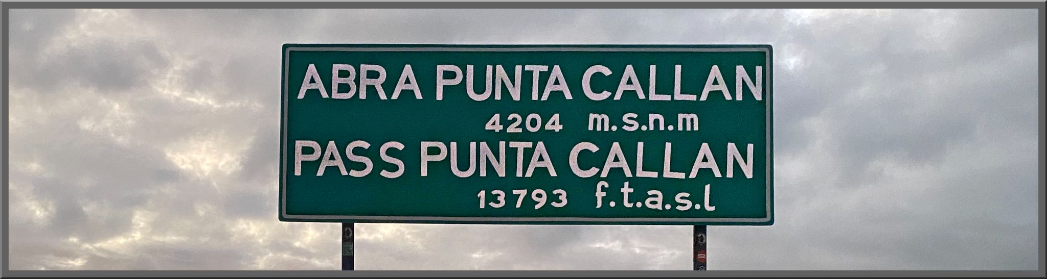Cycling Punta Callan East, Peru - green street sign reads "Abra Punta Callan - 4204 m.s.n.m; Pass Punta Callan 13793 f.t.a.s.l"