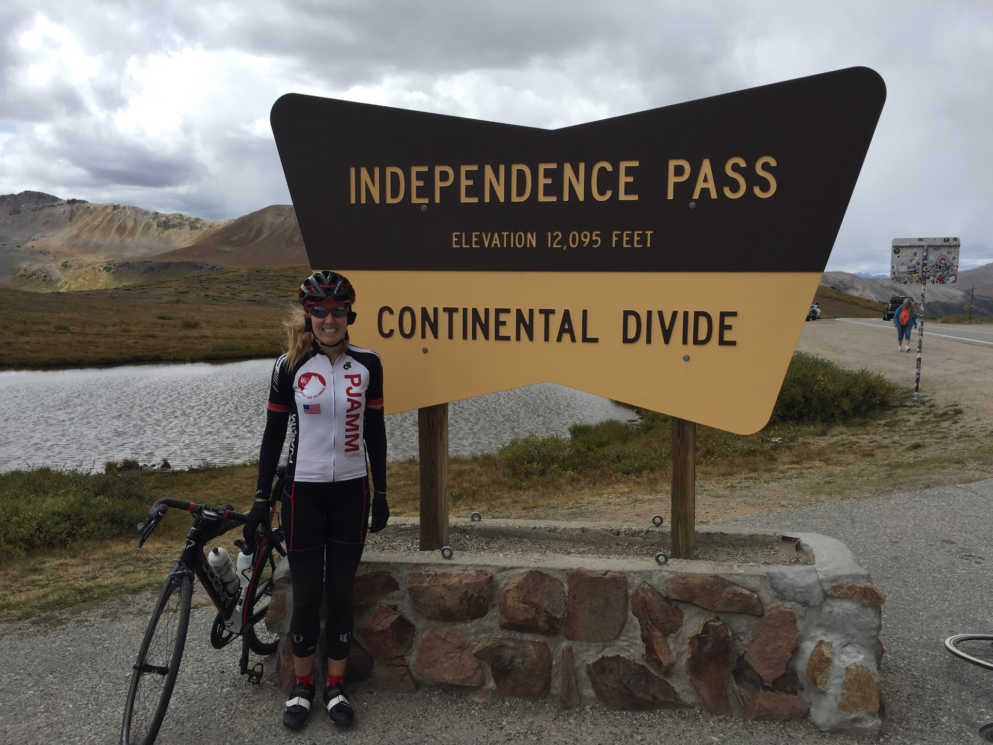 Bike climb Highest Colorado bike climb - cyclist at Independence Summit sign with bike