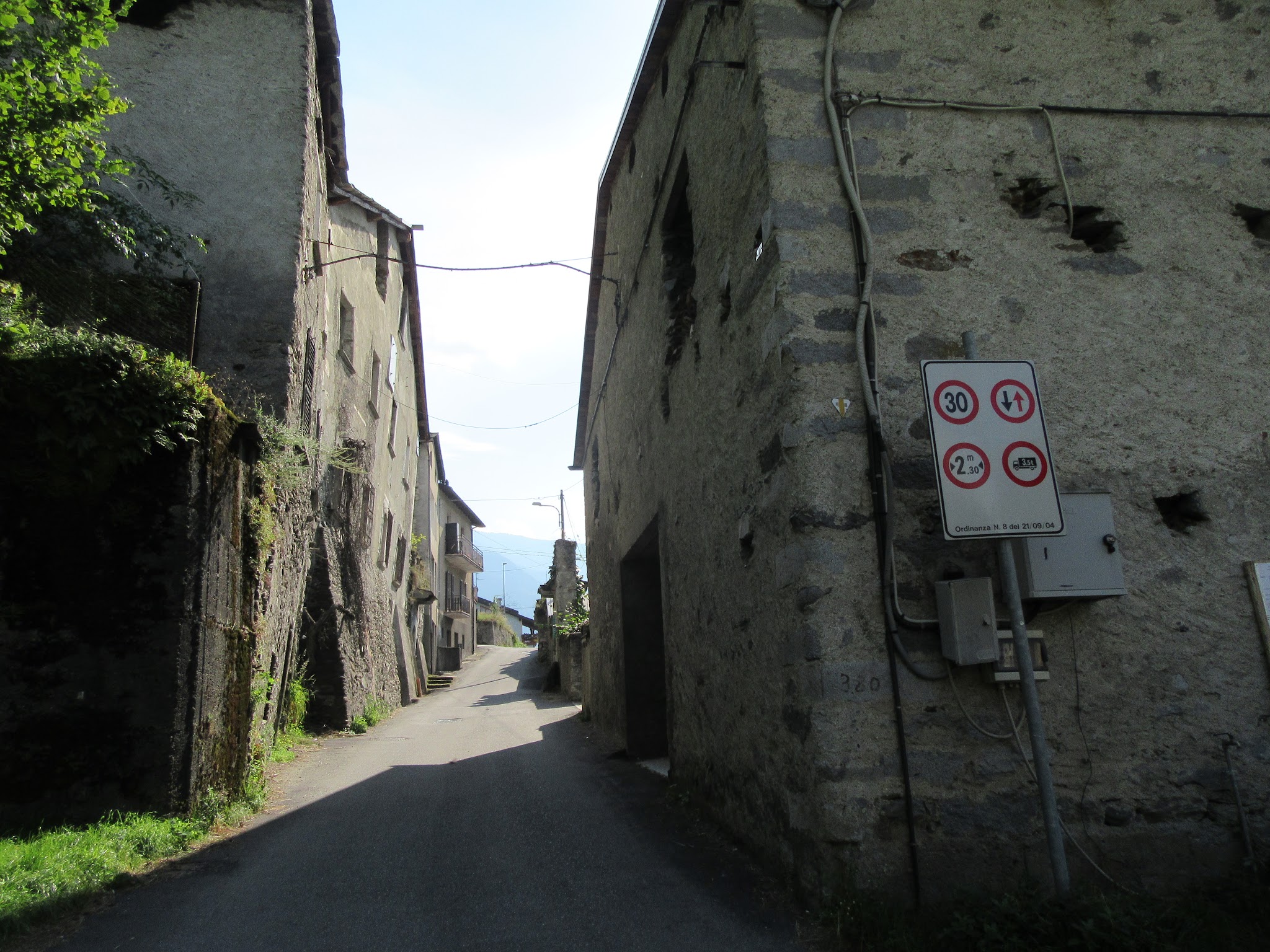 Cycling Passo del Mortirolo from Mazzo di Valtellina - start of climb, narrow road between old buildings