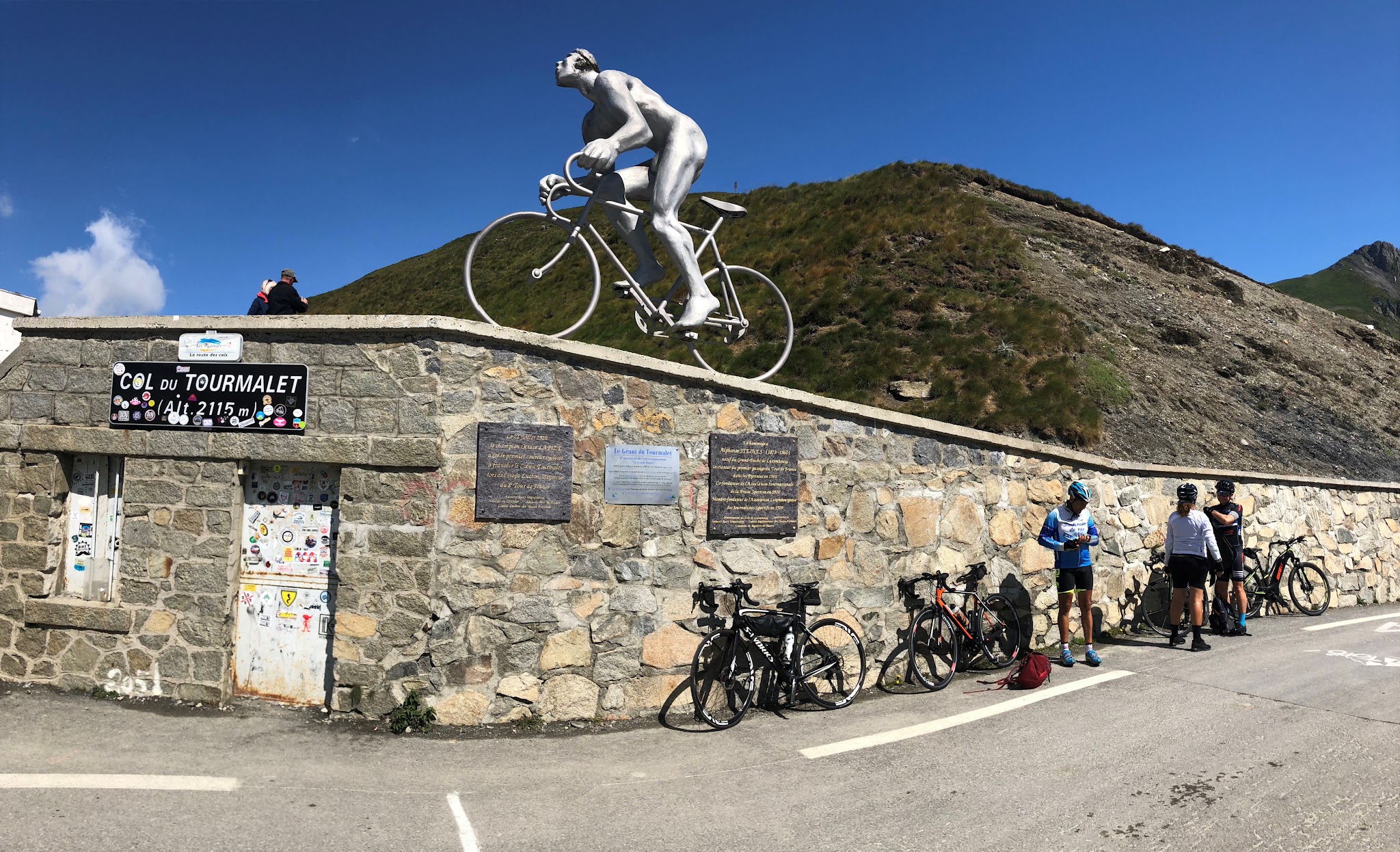 Bike climb up Col du Tourmalet - col - bicycles and cyclists; Le Geant statue, col sign