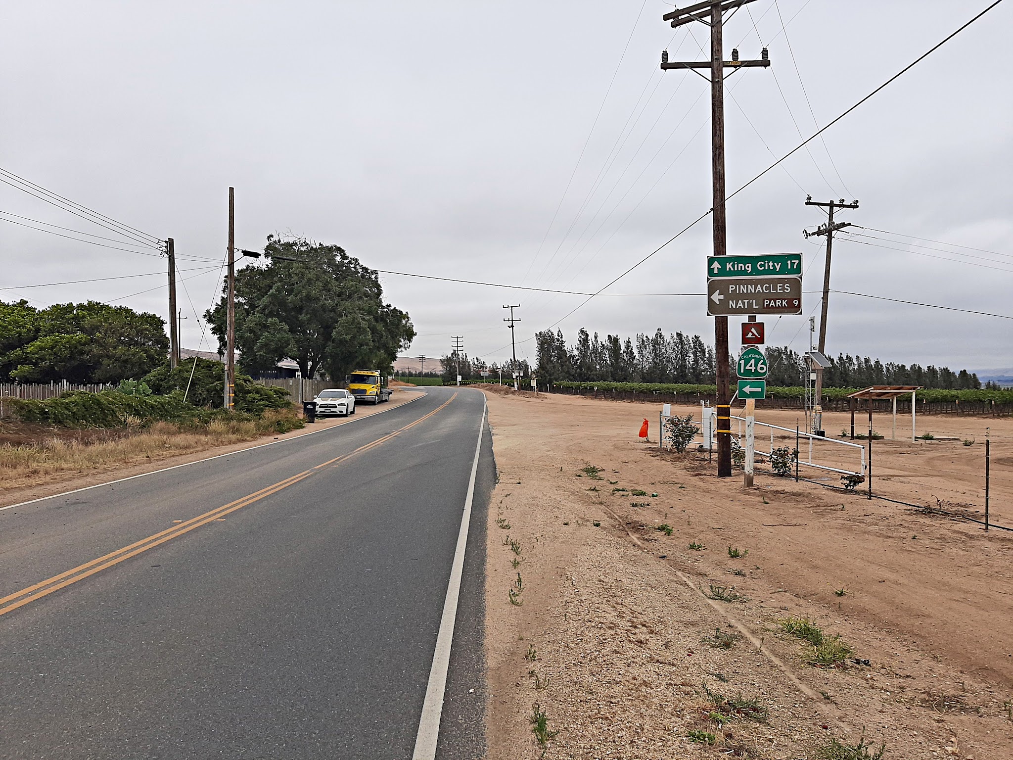 Cycling Pinnacles National Park, California - two-lane roadway surrounded by dirt and brown grass, road signs for King City, Highway 146, and Pinnacles National Park