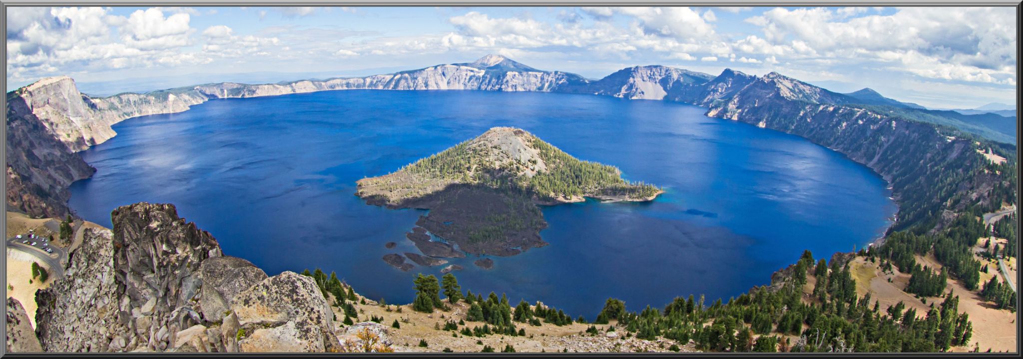Aerial Drone view of deep blue, circular Crater Lake with cone shaped island in center