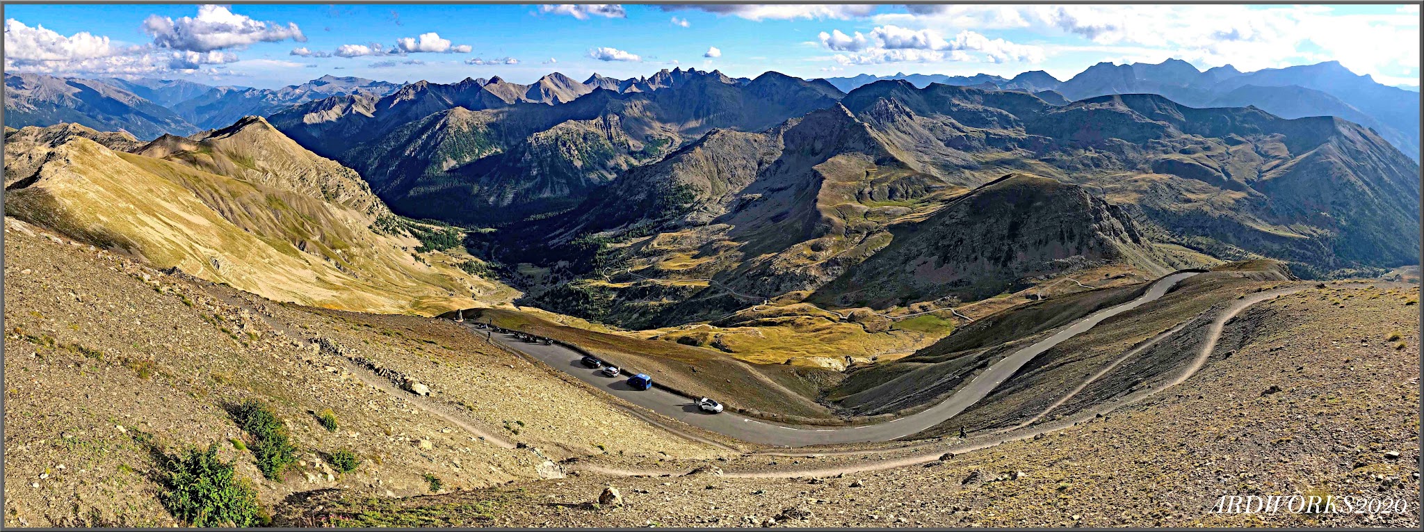 Cycling Cime Bonette from Jausiers - view looking down mountainside to roadway below, mountain ranges in the distance