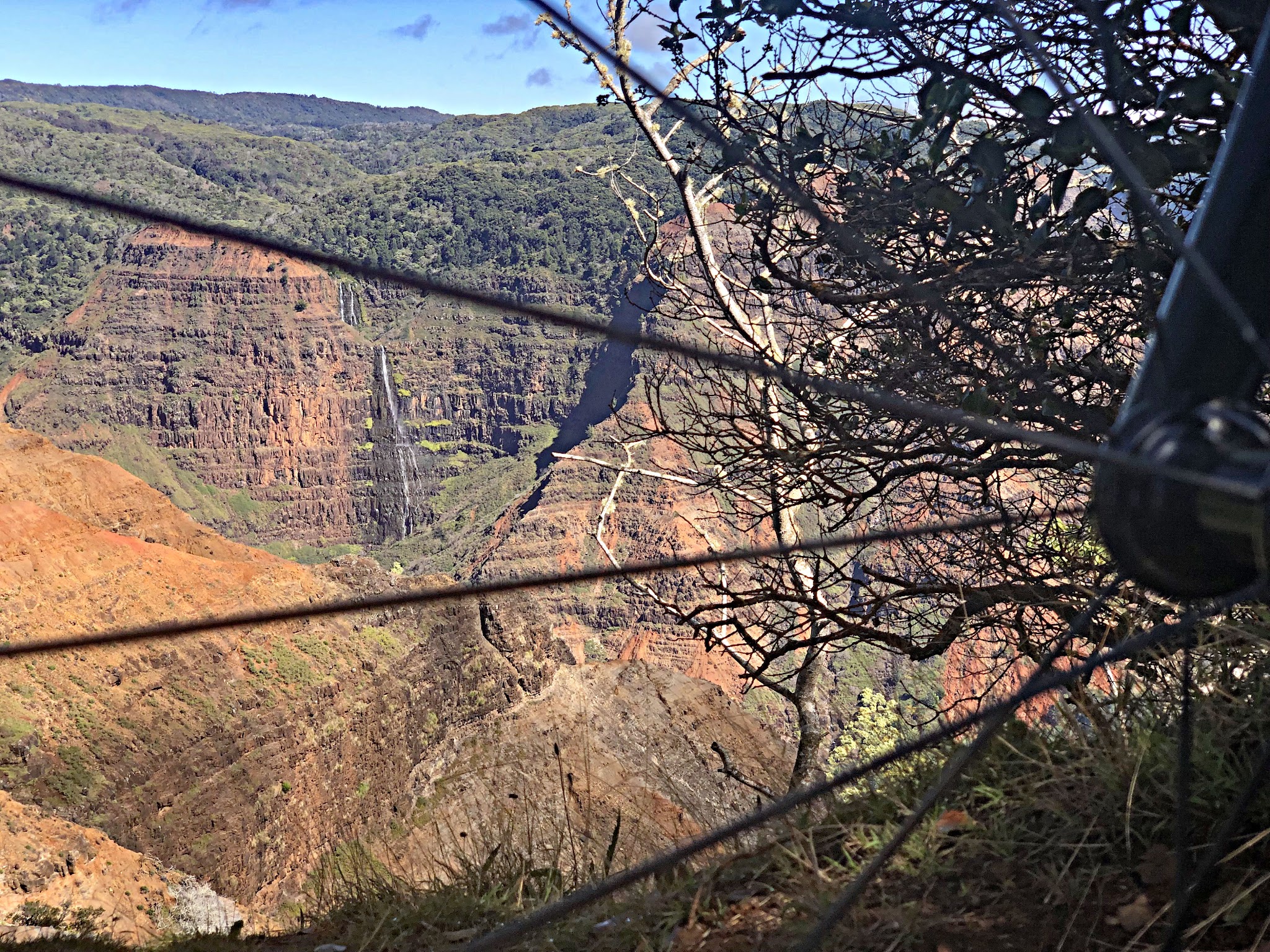 looking out at Waipo’o Falls across the canyon through the spokes of the a bike