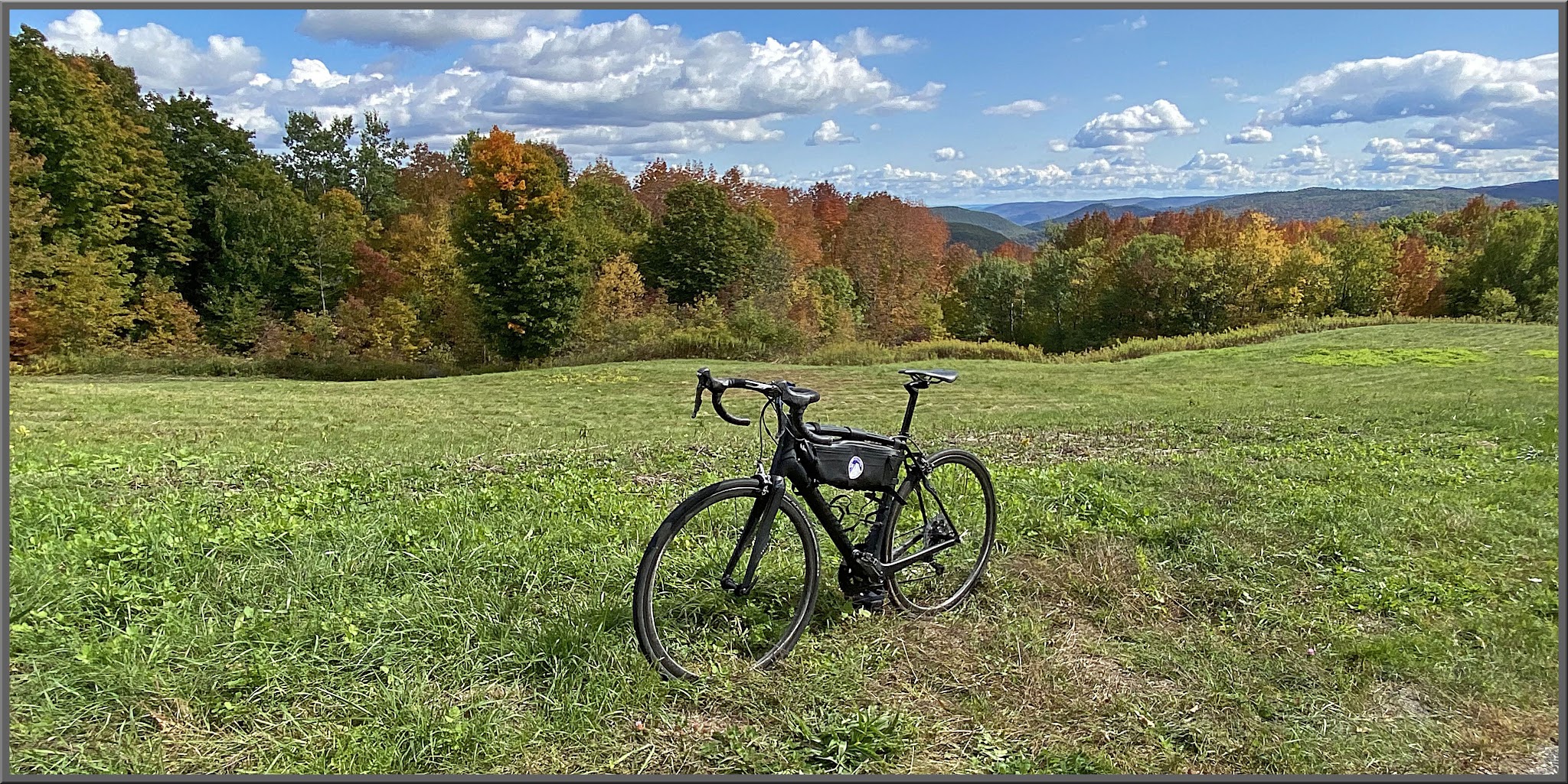 Cycling Whitcomb Hill Road, Massachusetts - bike parked in green field surrounded by blue sky and fall foliage