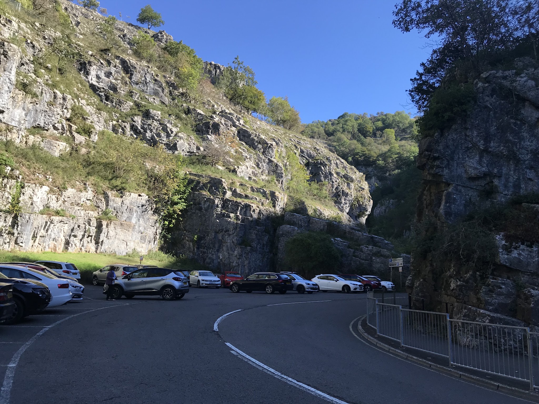 Cycling Cheddar Gorge - winding road leading into parking lot lined with limestone rock walls