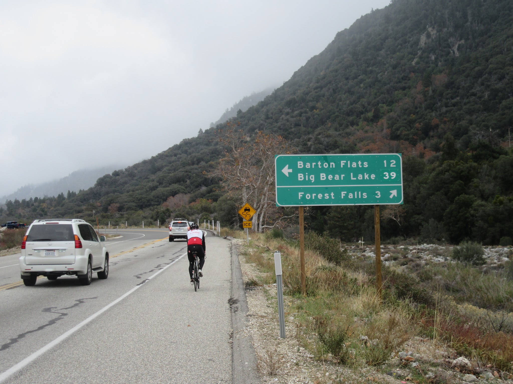 Cycling up Highway 38 to Onyx Summit  - cyclist and road sign to Valley Falls