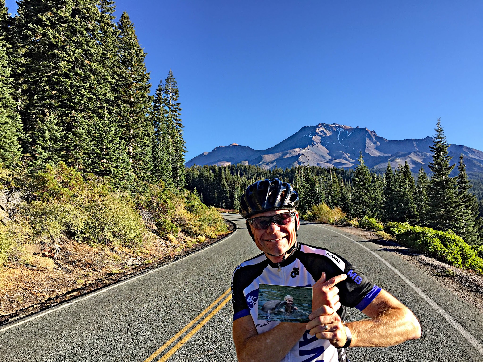 PJAMM Cyclist stands in roadway with Mt. Shasta behind him