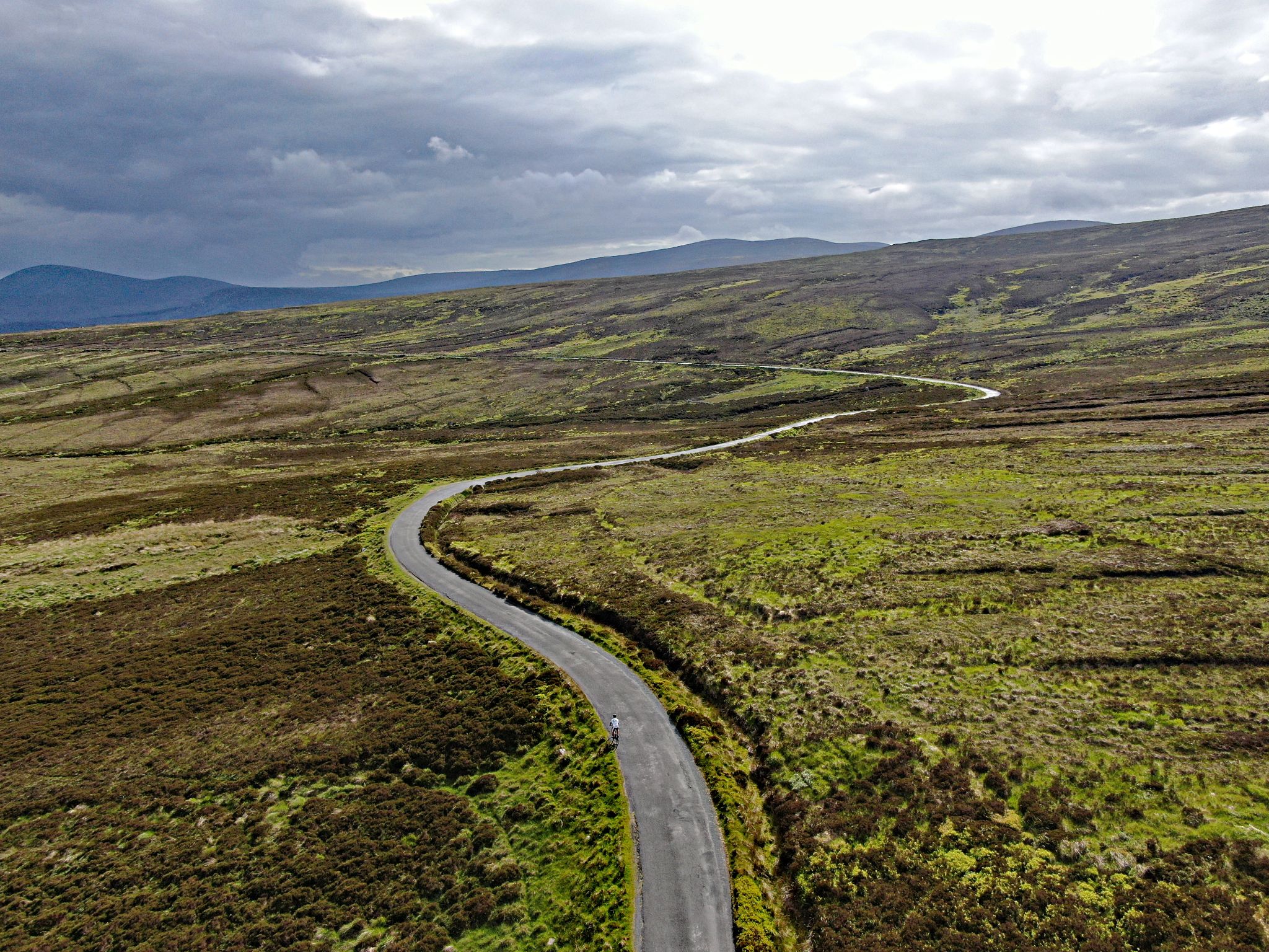 aerial drone view of road snaking through open pastureland in Wicklow Mountains National Park