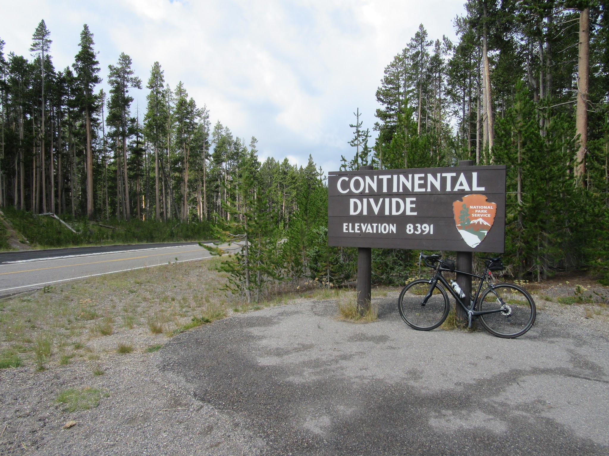 Cycling Yellow Stone National Park - bike leaning against Continental Divide sign.