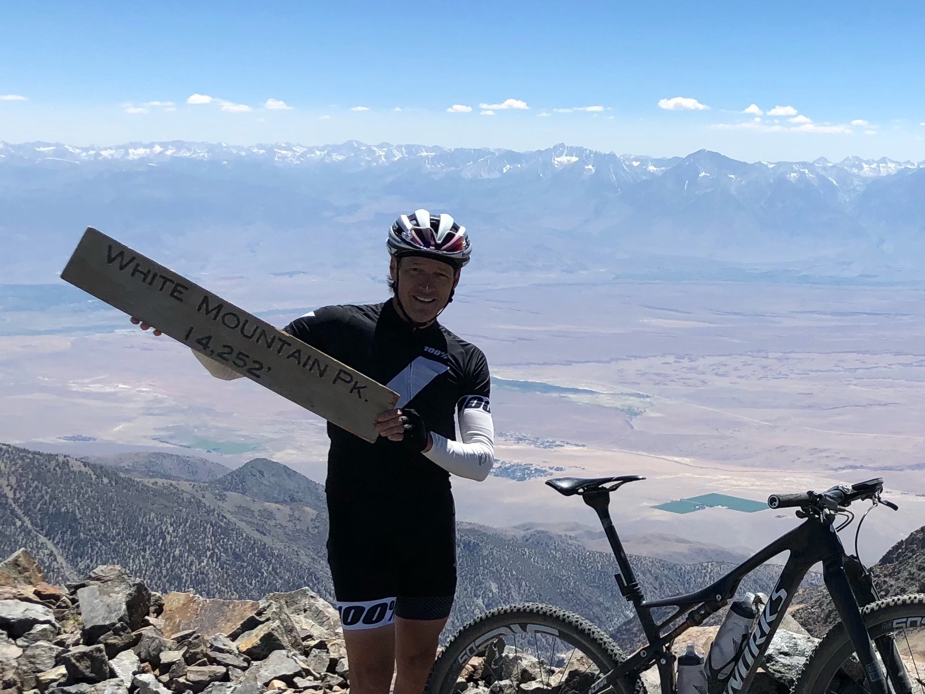 White Mountain Peak from Big Pine, California - Cyclist Greg Matherly stands at White Mountain peak holding elevation sign, next to his bike