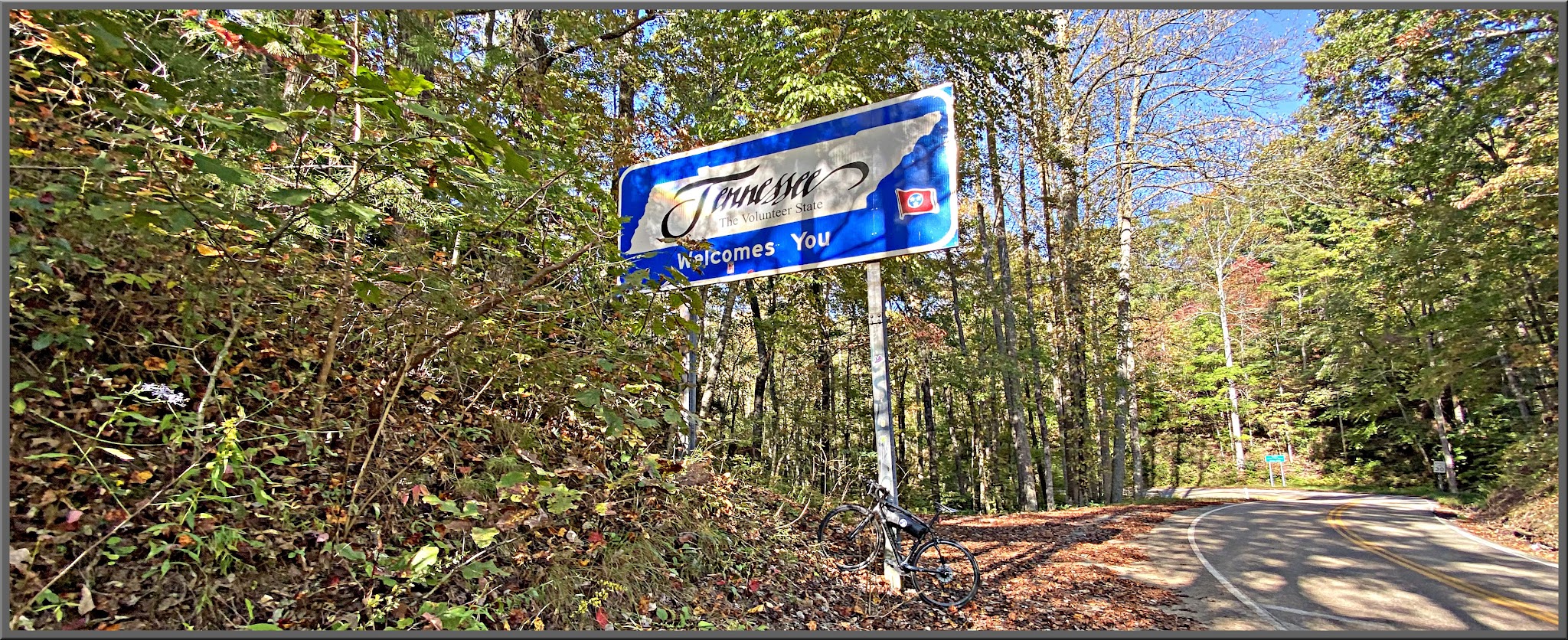 Cycling Head of the Dragon, Tennessee - sign for Tennessee in a densely forested area
