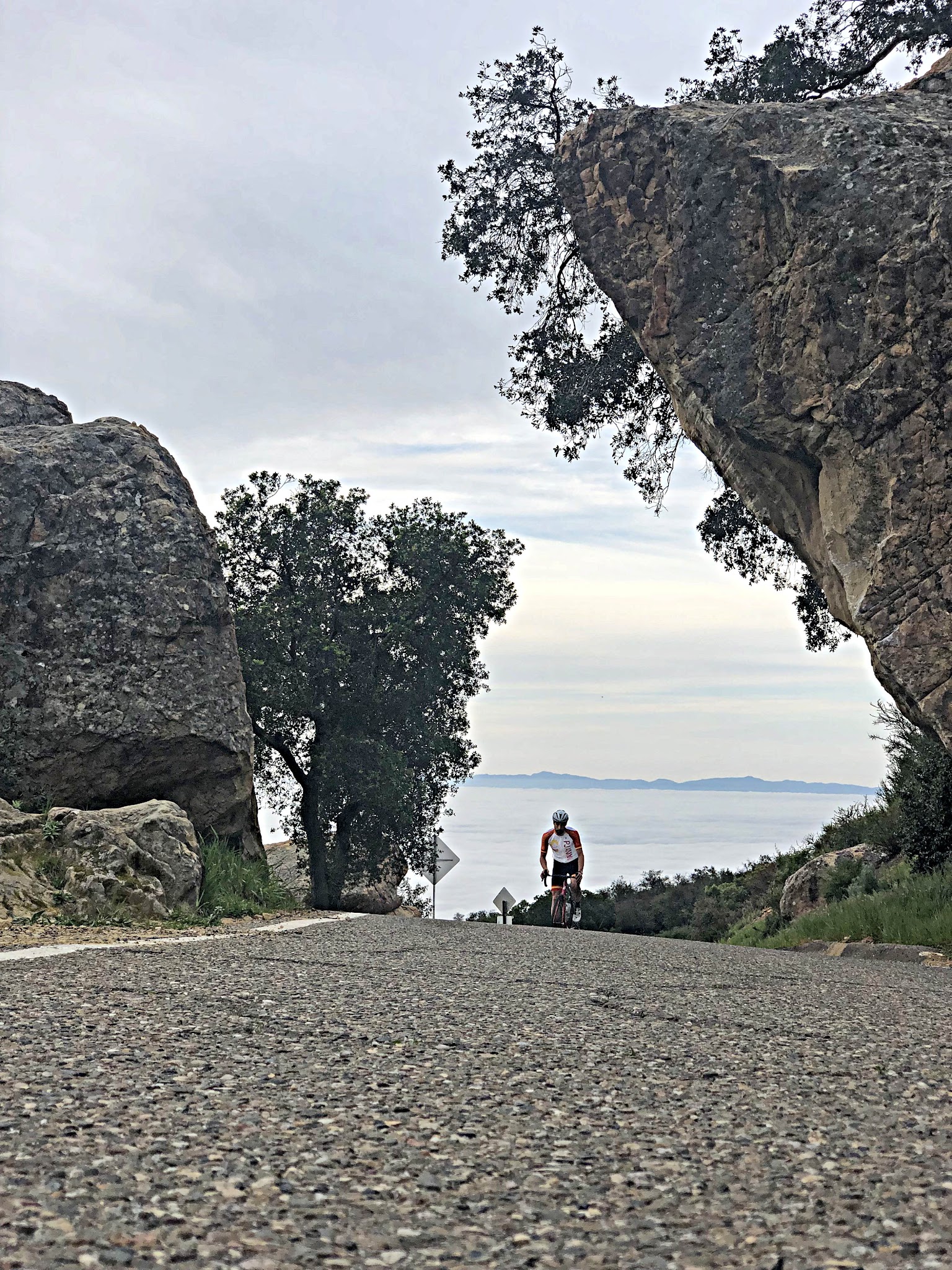 Cycling San Marcos-Painted Cave Roads - cyclist riding between rocks on road