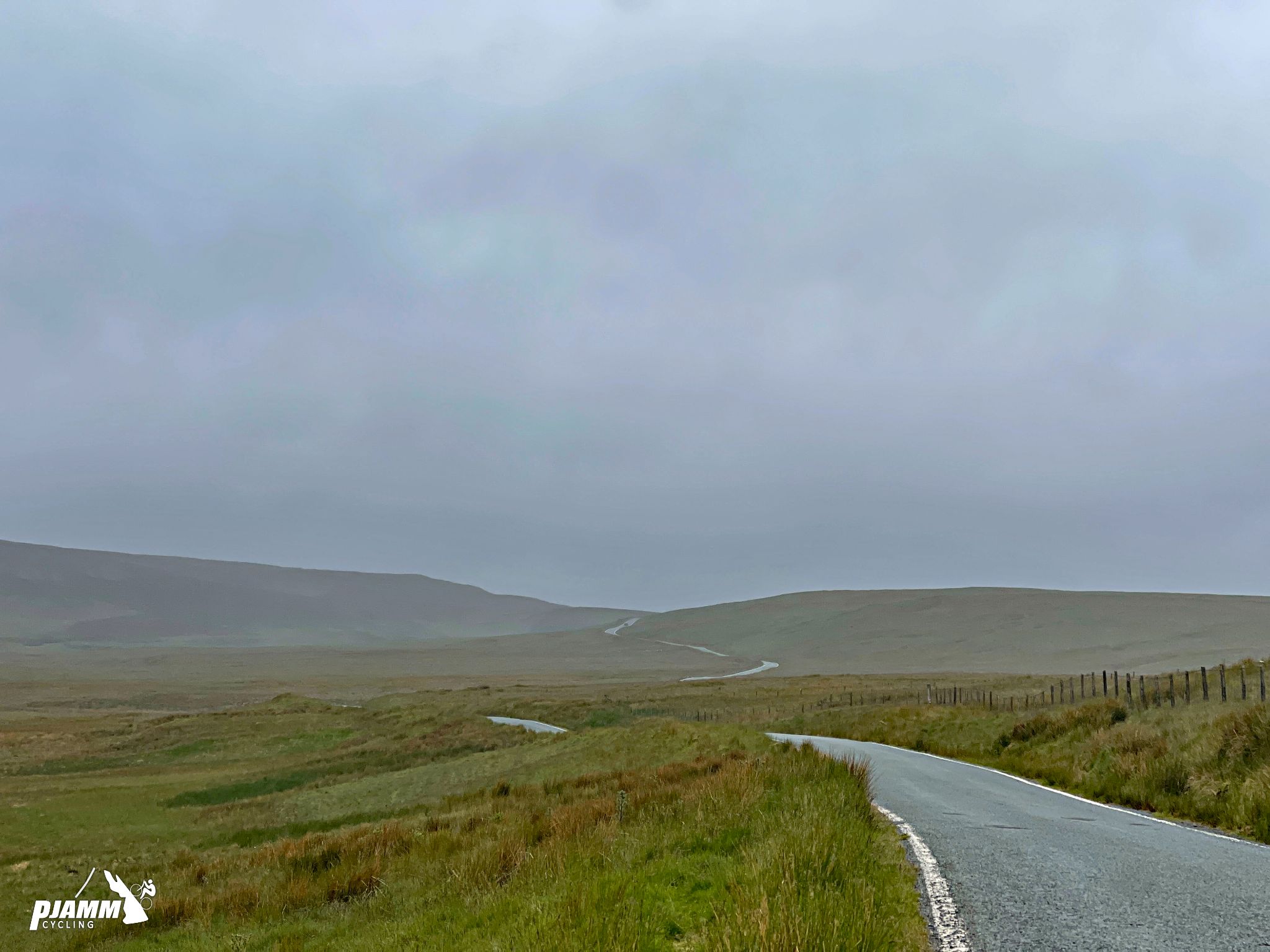 Cycling Migneint Pass, Wales one-lane roadway snakes through open moorland, misty, foggy day