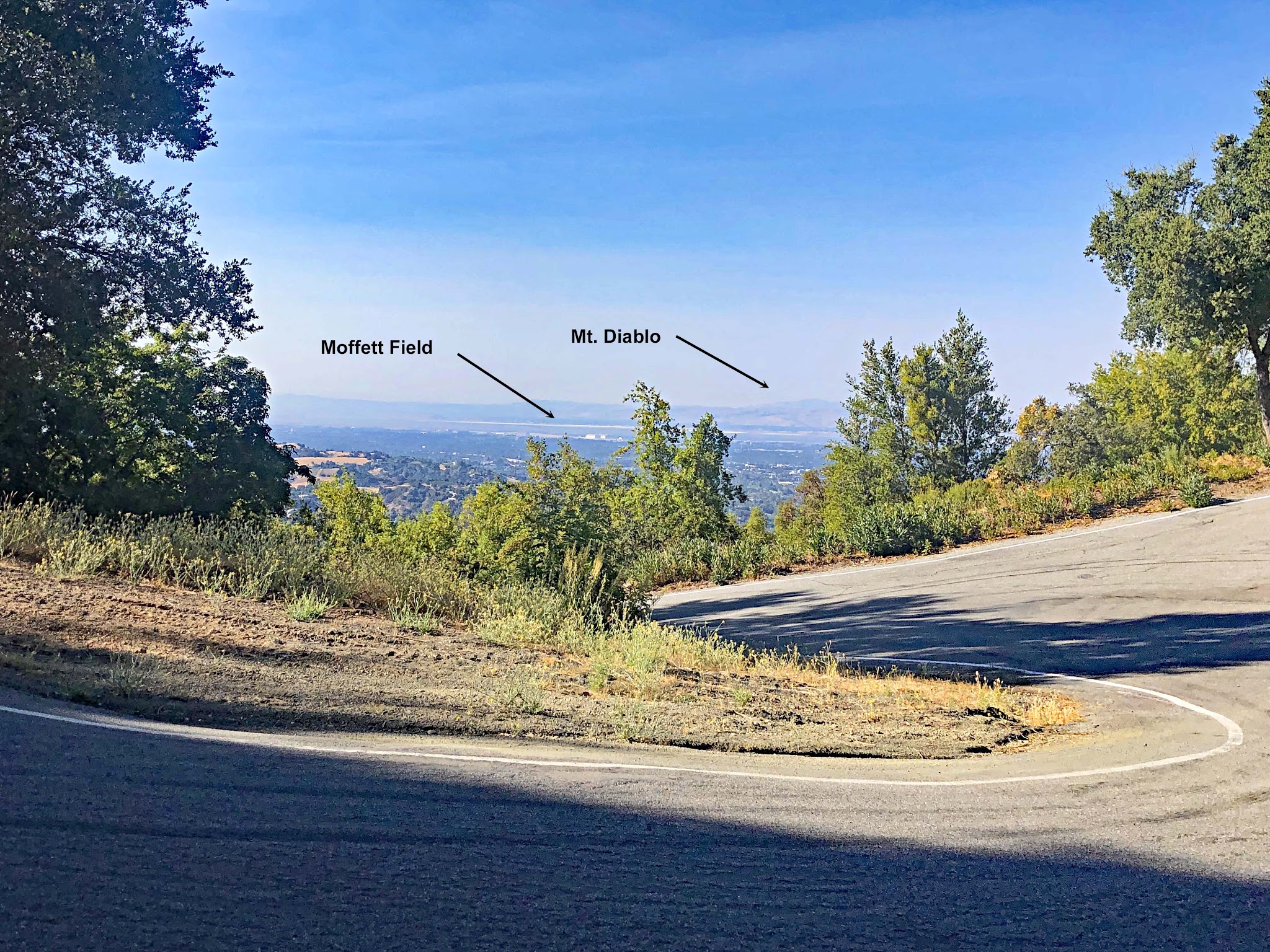 Cycling Bohlman Road, Saratoga, California - sharp hairpin turn on roadway overlooking Moffett Field and Mt. Diablo