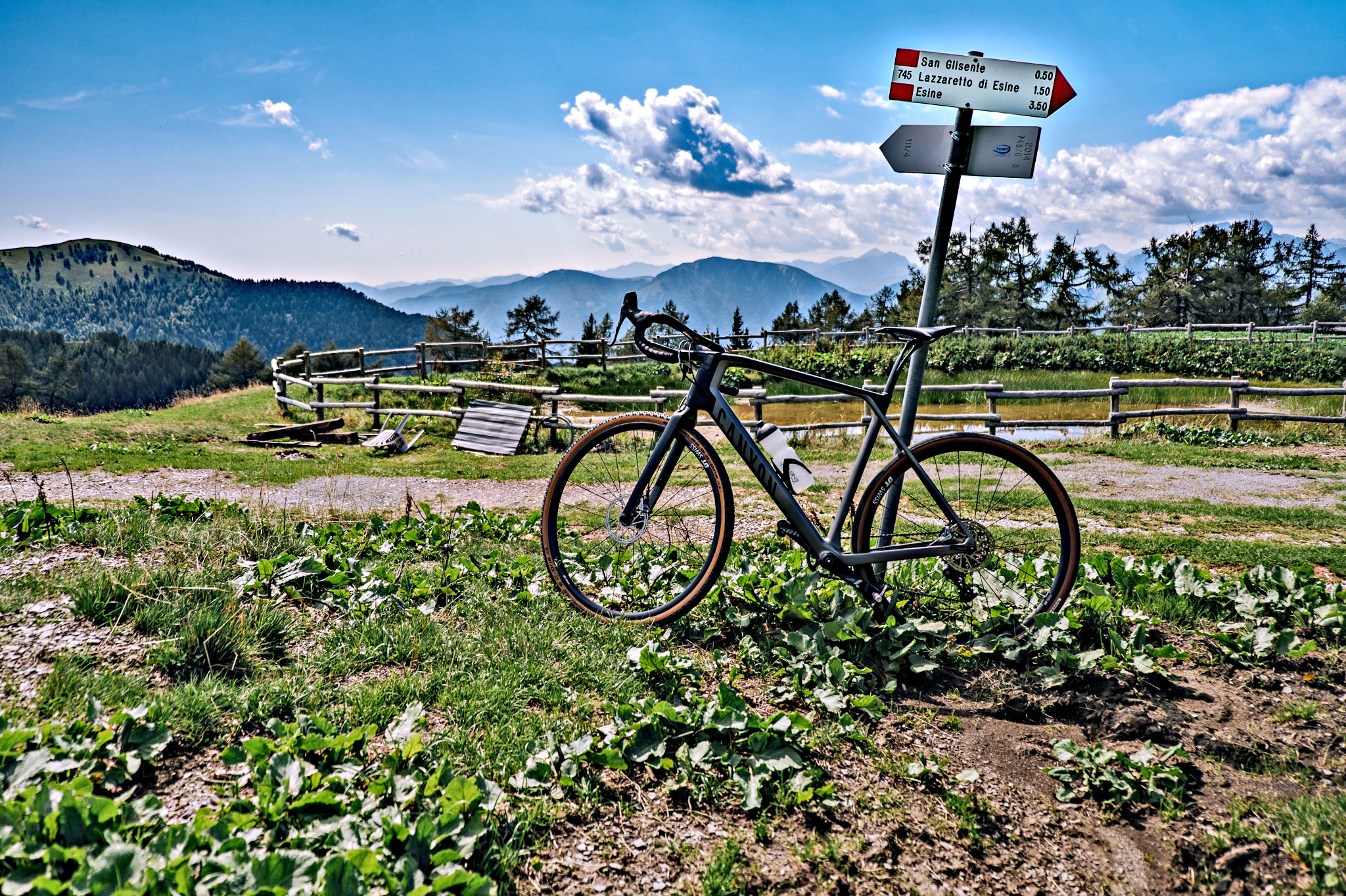 Cycling Pozza San Glisente, Italy - bike parked next to road sign for San Glisente 
