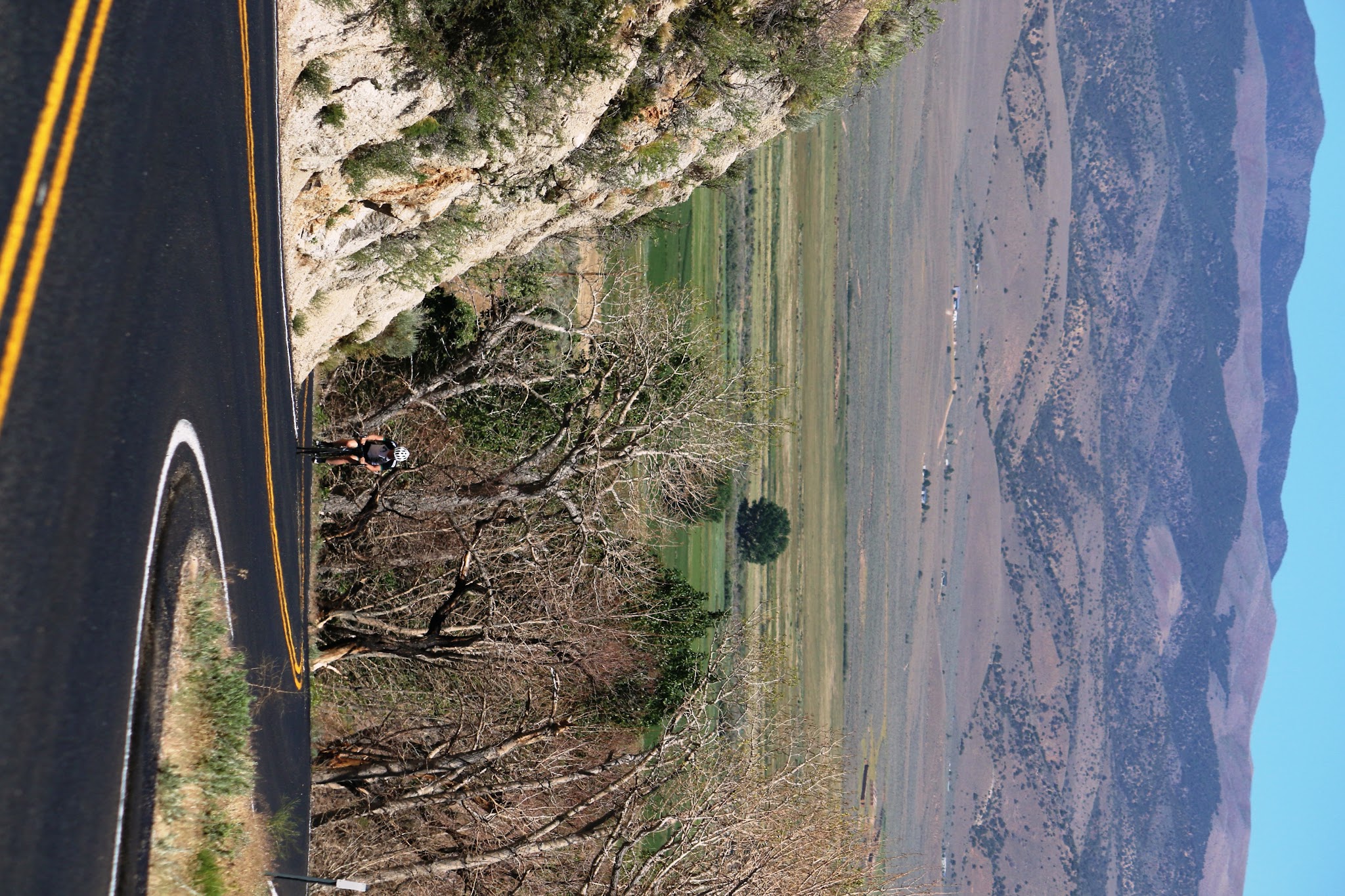 Bicycle ride up Monitor Pass East  - cyclist on roadway with view east of valley and mountains