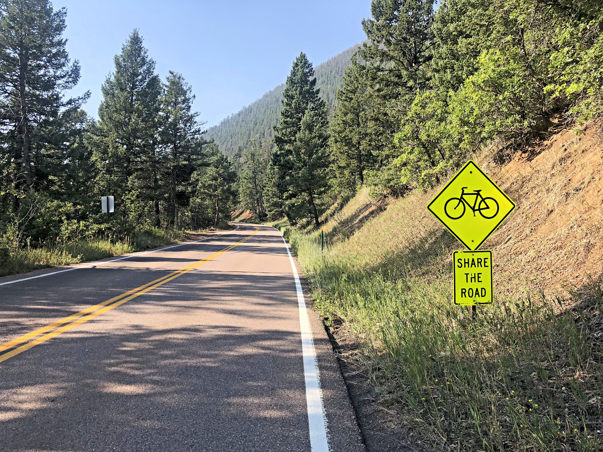 Cycling Pikes Peak - straight segment of two-lane roadway, share the road sign