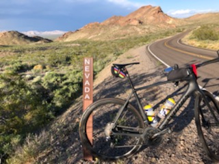 Cycling Daylight Pass Death Valley - bike leaning against state border nevada sign