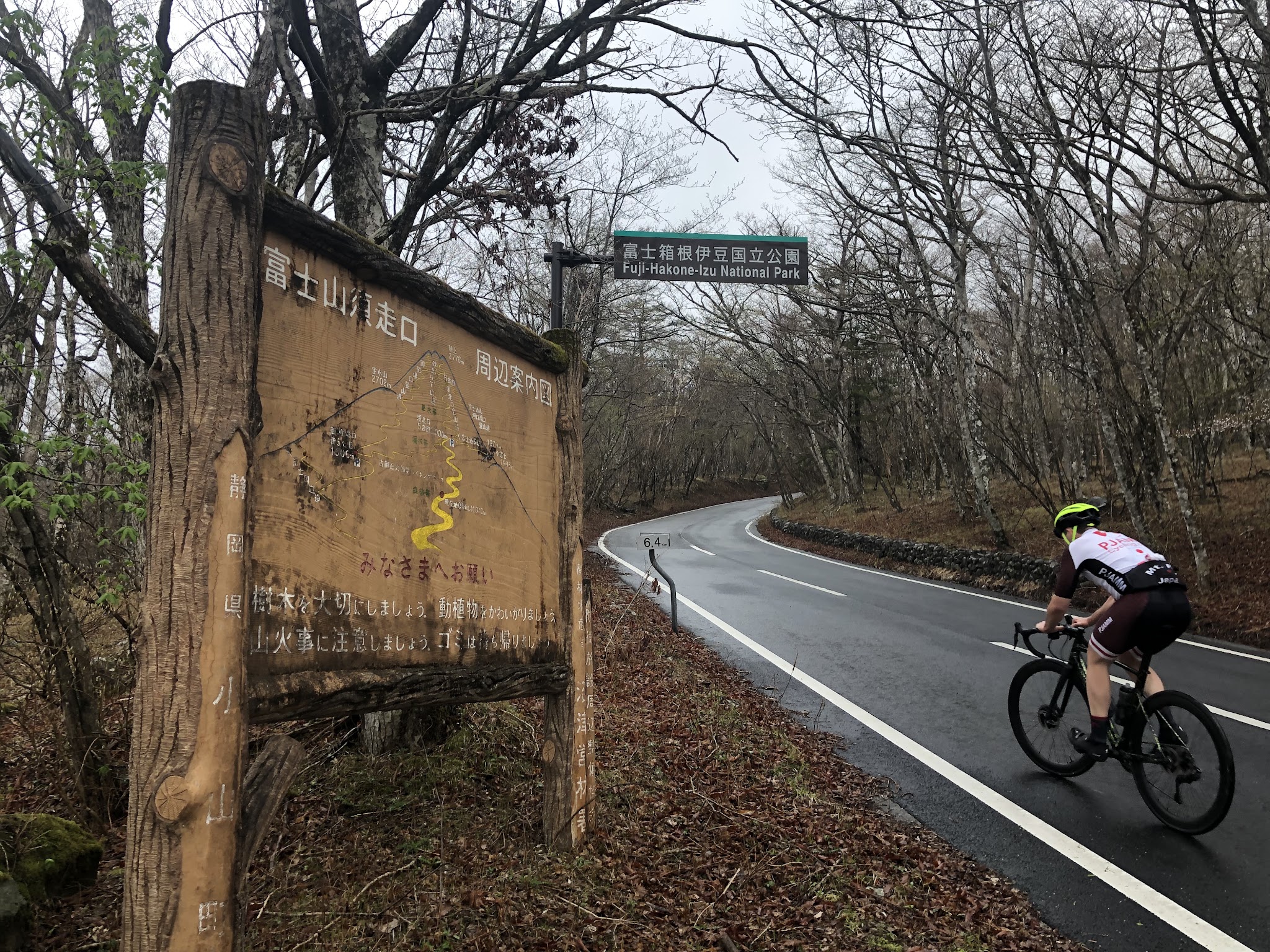 BikingMt. Fuji Azami Line - cyclist on road passing Mt. Fuji Azami line road sign