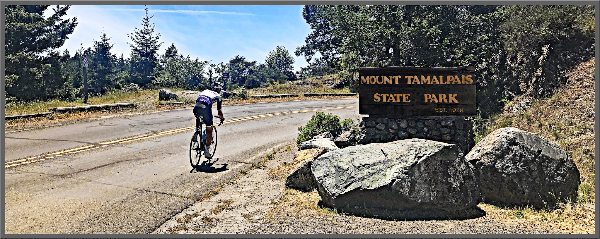 Cycling Golden Gate Bridge to Mt. Tam, California Cycling Golden Gate Bridge to Mt. Tam, California - cyclist rides on roadway next to sign for Mount Tamalpais State Park