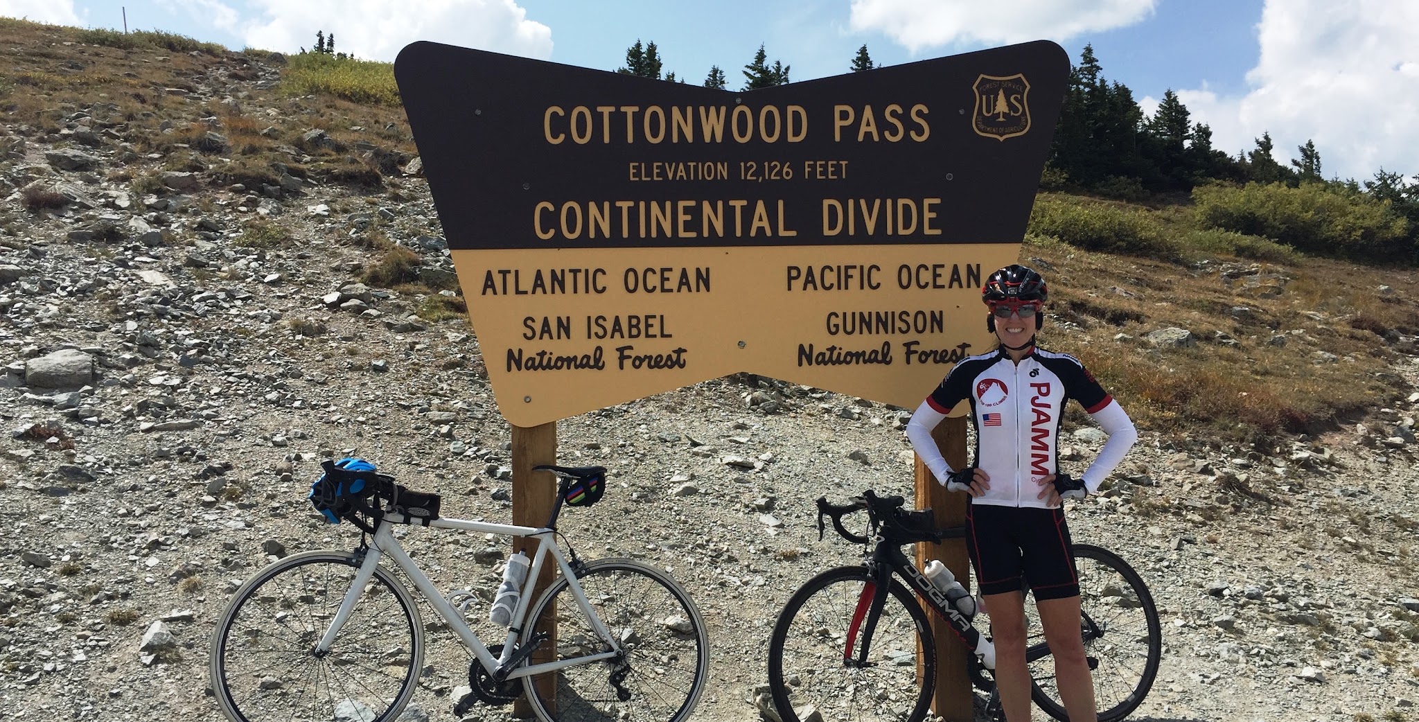 Cycling Highest Colorado bike climb - cyclist at Cottonwood Pass summit sign with bike