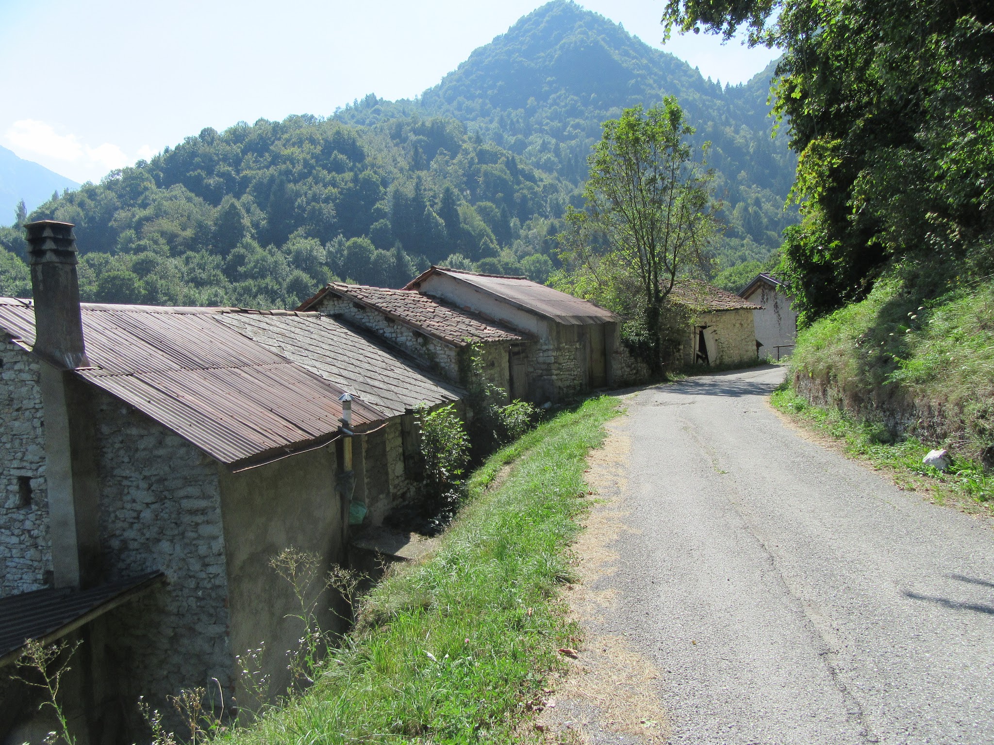 Biking up Monte Grappa from Seren - road and old buildings with mountains in background