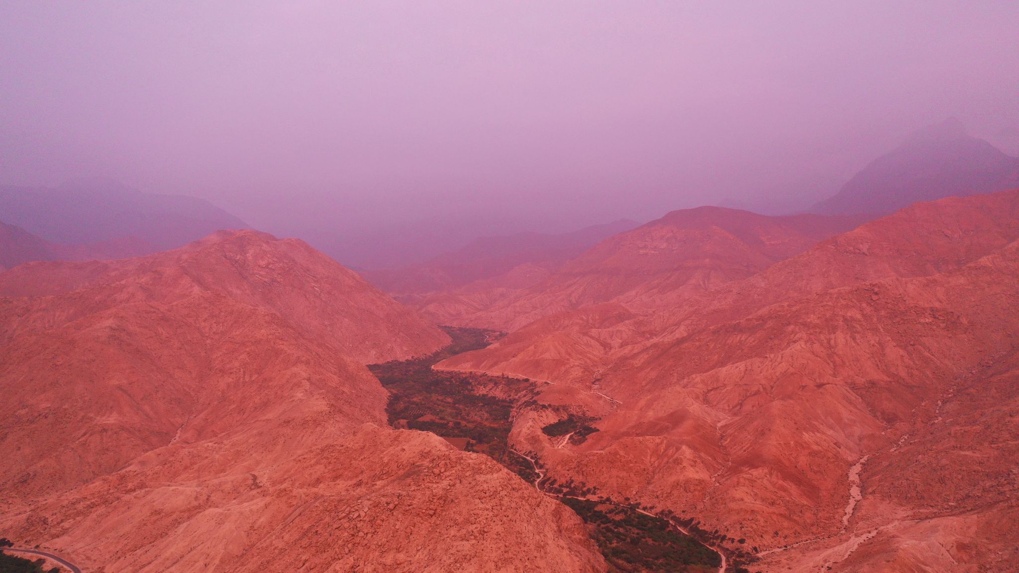 Cycling Conococha, Peru - aerial view shows mountains and valley, pink tinted