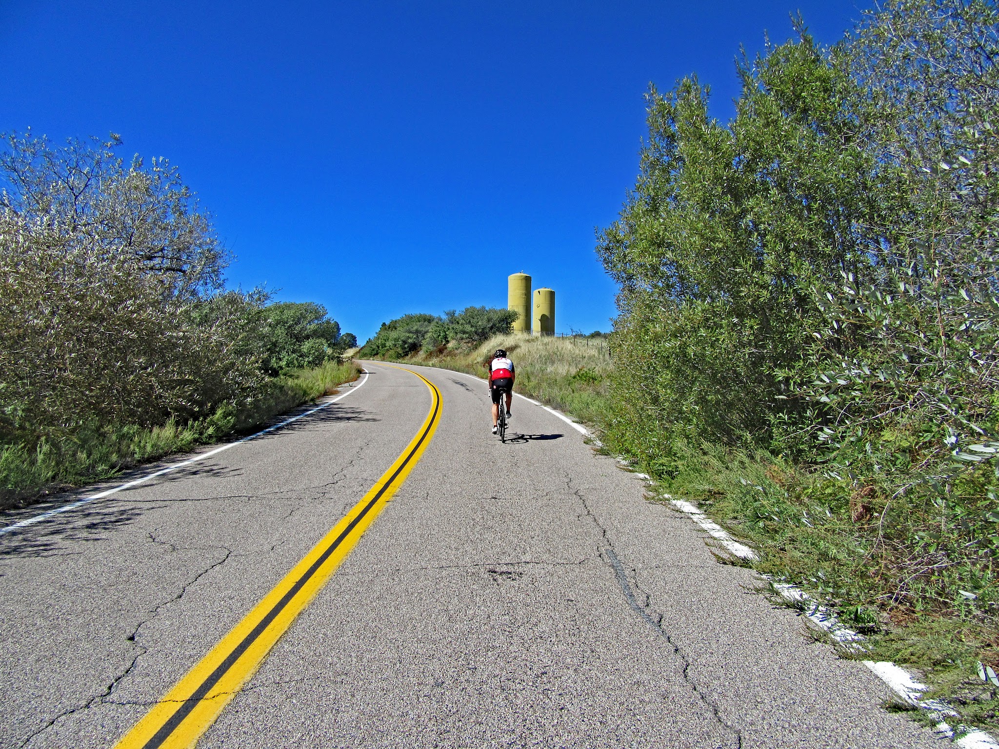Riding East Grade Road by bike - cyclist and silos