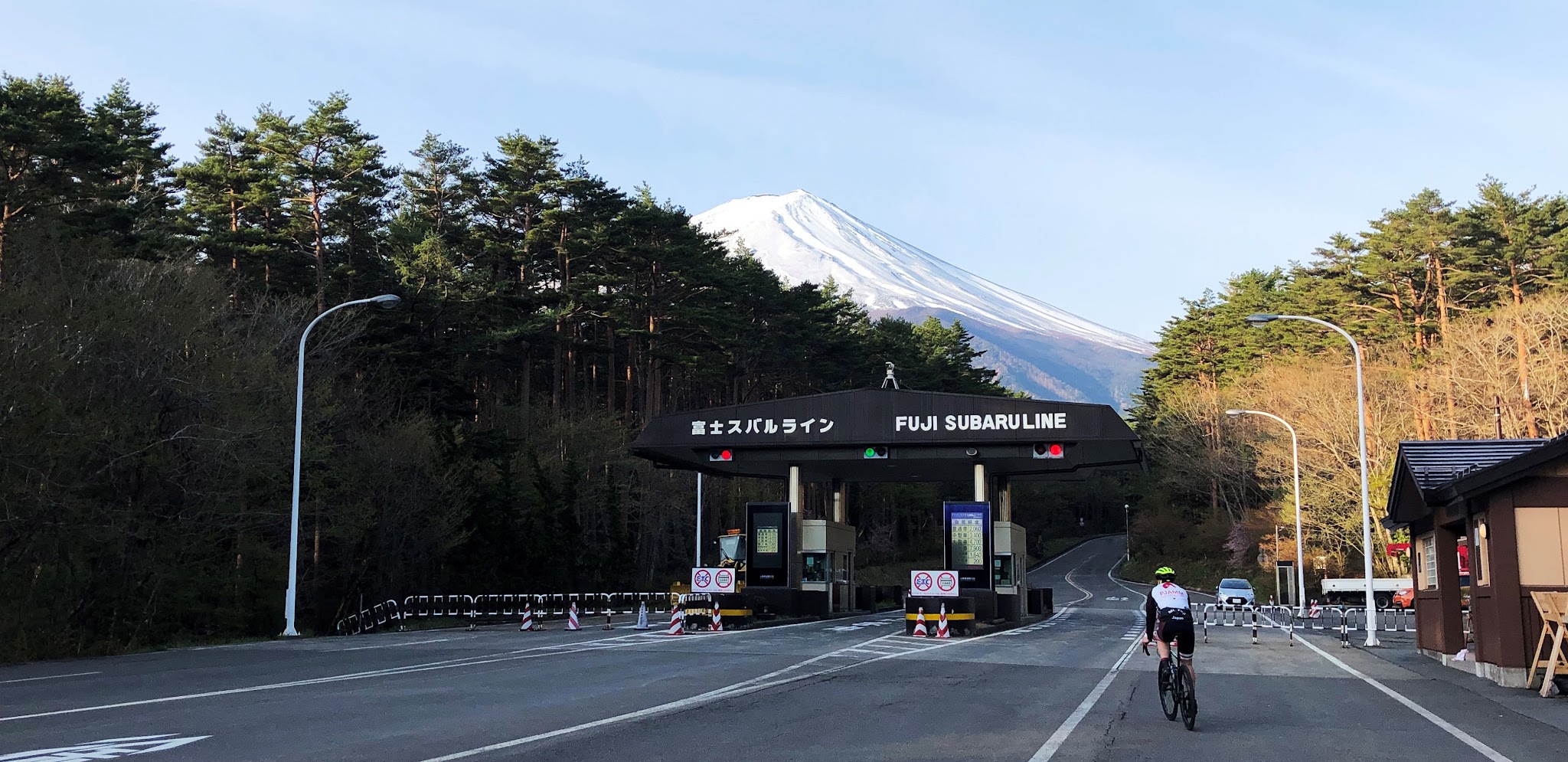 Cyclist riding past the Subaru Line toll booth - Mt. Fuji in background.