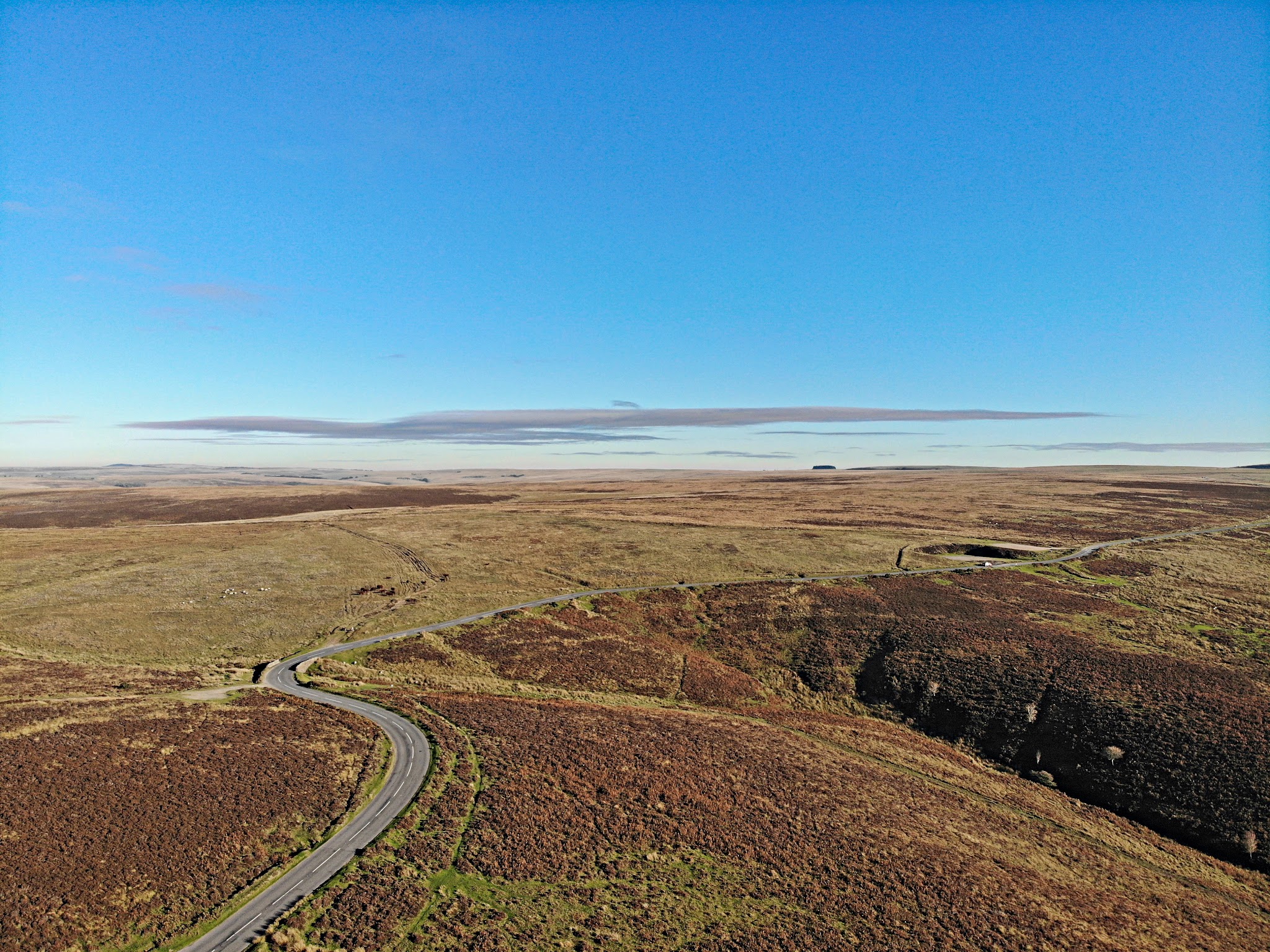 Cycling Exmoor Forest, England - view looking down hillside from top of climb, wide open spaces, road winding through center of hillside