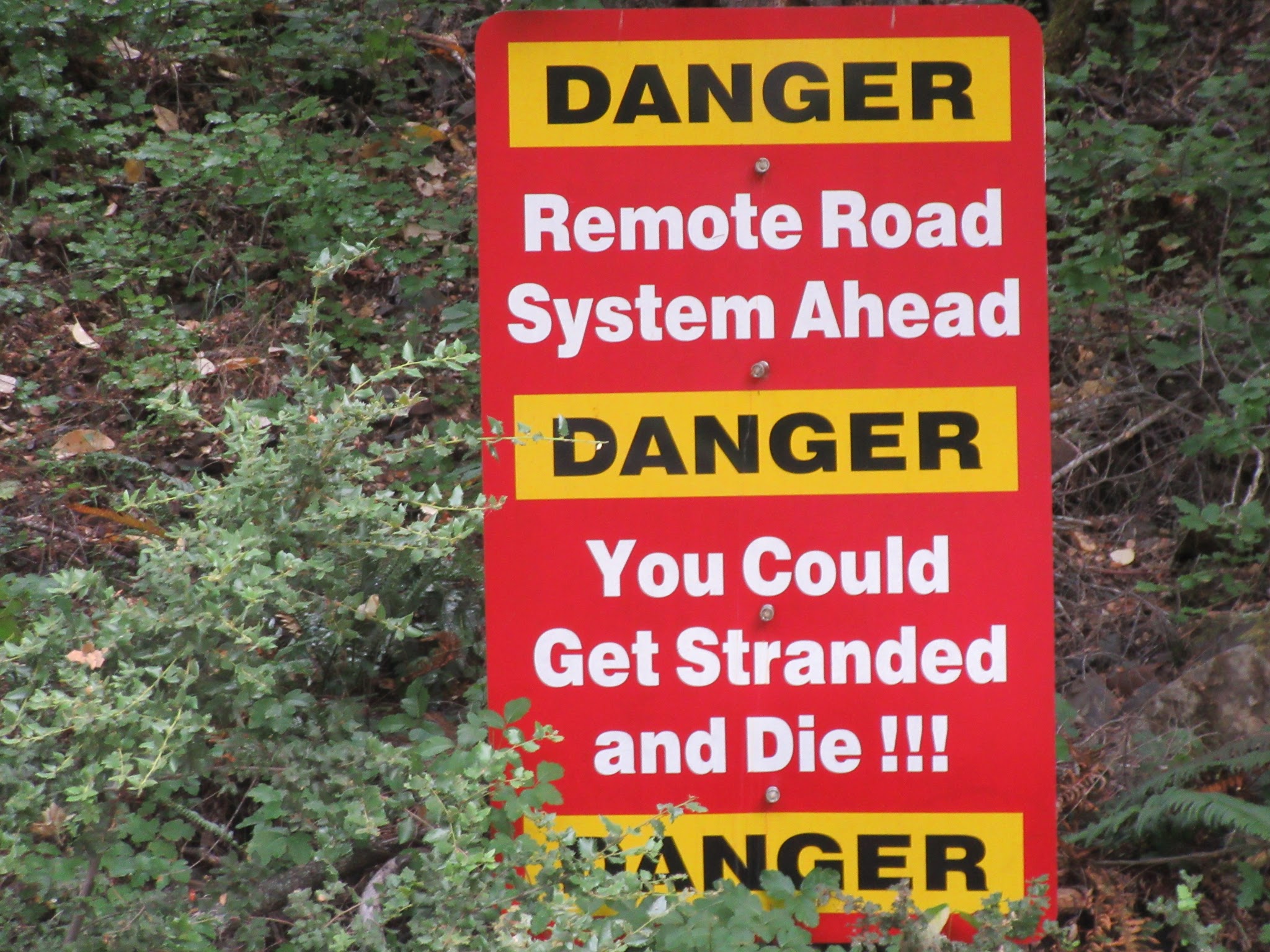 Sign reads "Danger Remote Road System Ahead, Danger you could get stranded and die!!! Danger"