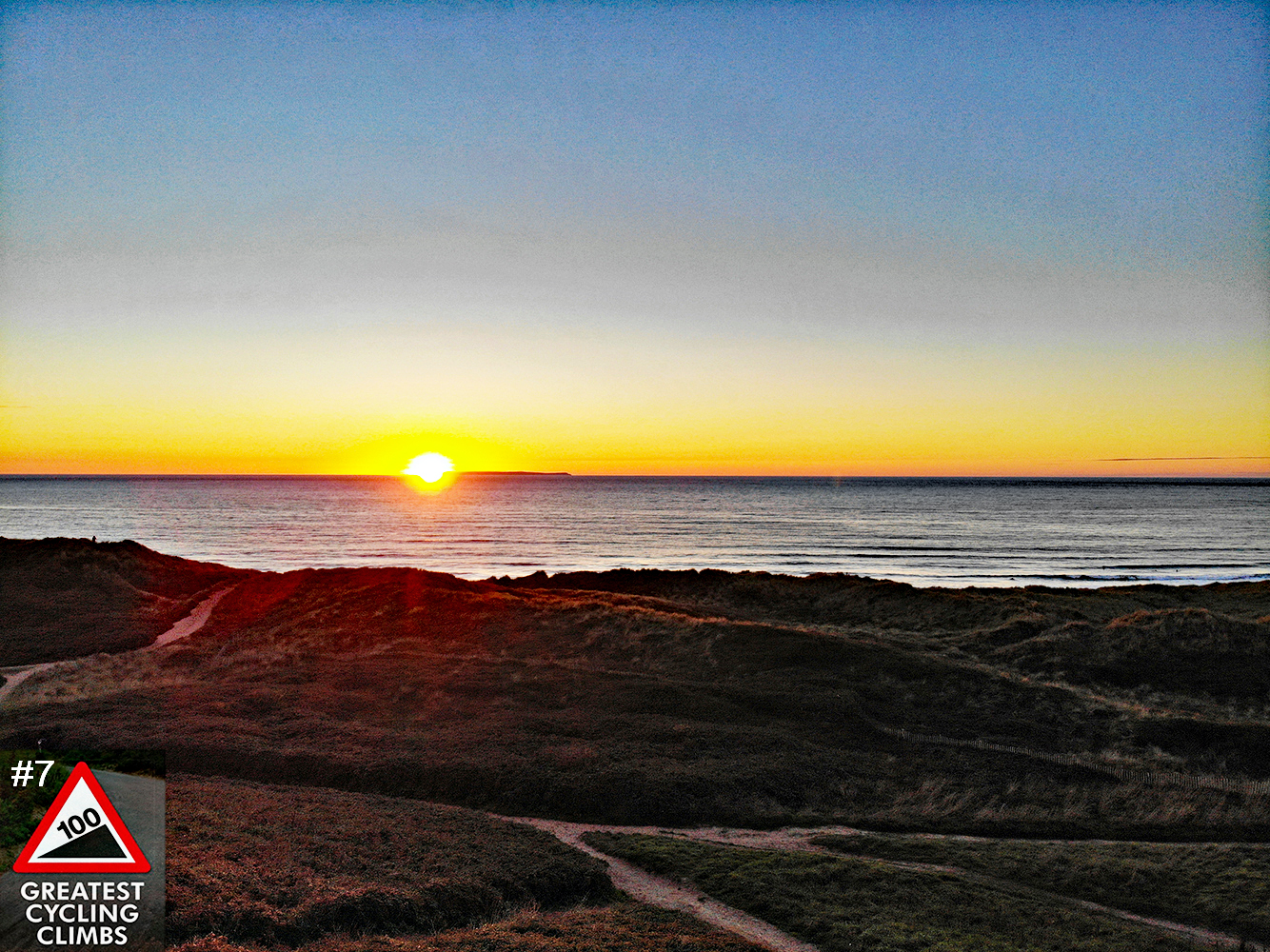 Cycling Challacombe Hill - sunset over water, rolling hills in foreground, Simon Warren's 100 Greatest Cycling Climbs #7 Logo in corner
