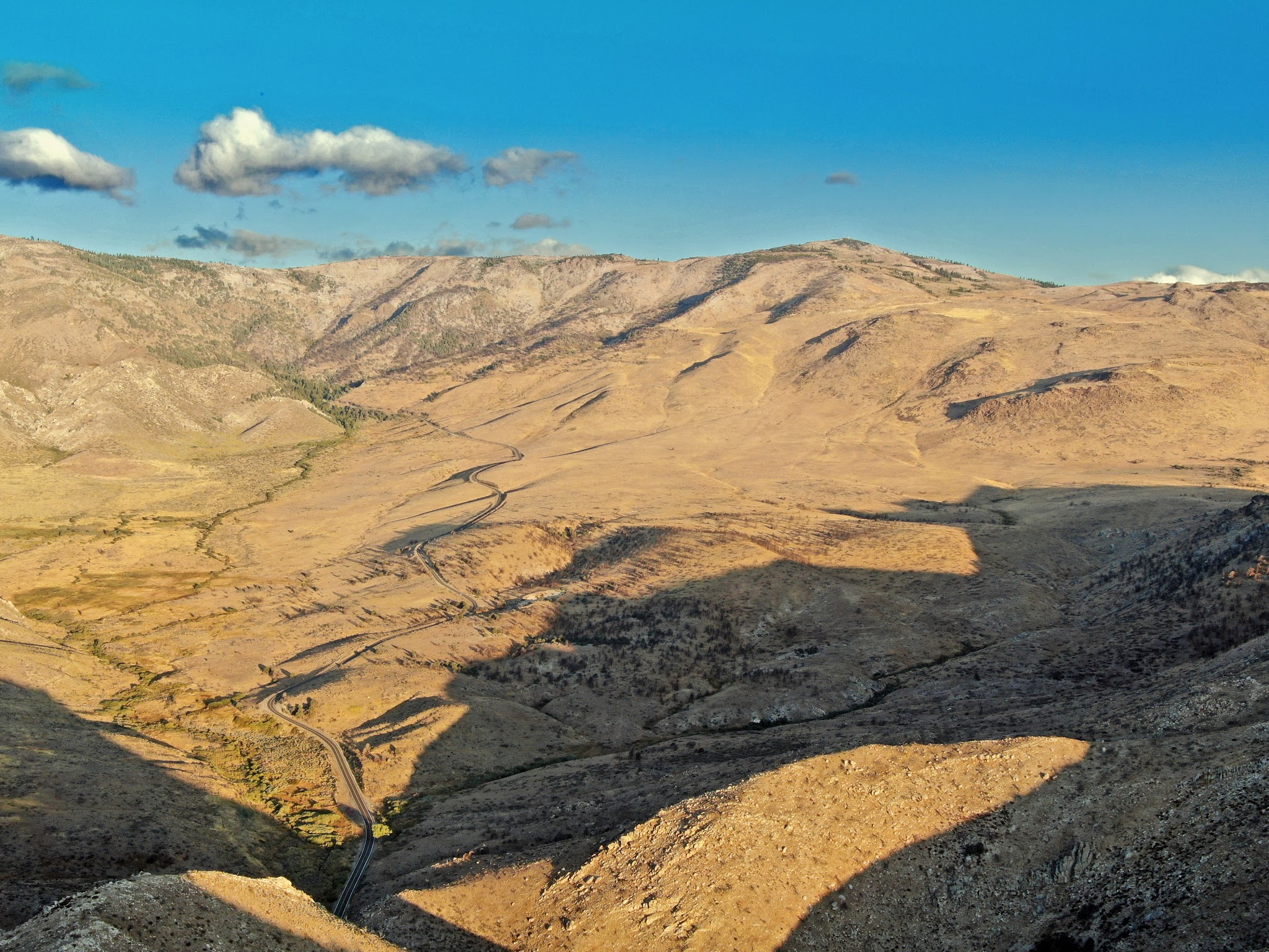 Climbing Monitor Pass East  by bicycle - Death Ride cyclists descending through canyon