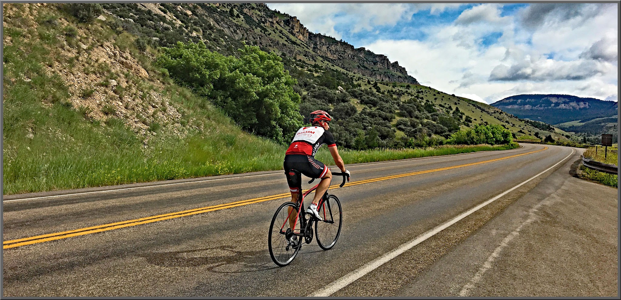 Cycling Powder River, Wyoming - cyclist rides on straight portion of two-lane road