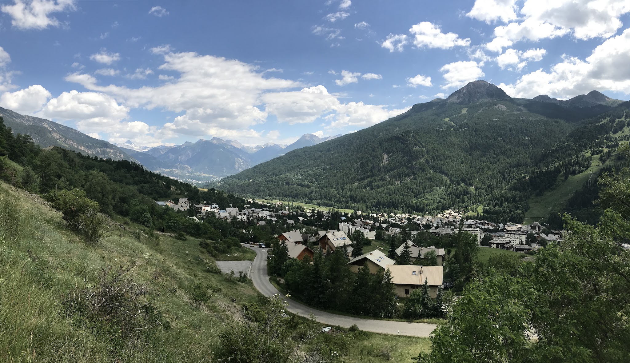 view looking down on mountain village surrounded by lush green mountains
