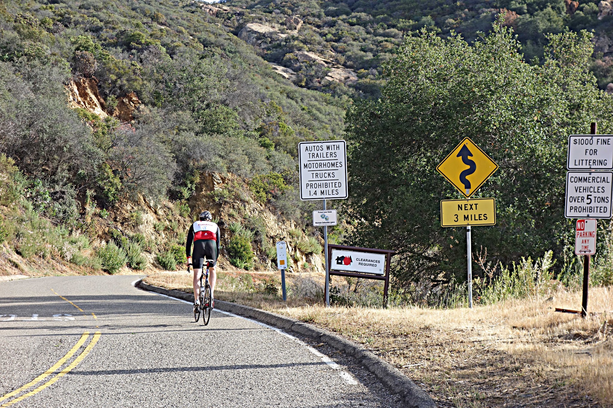 Climbing by bike San Marcos-Painted Cave Roads - cyclist crossing hwy 