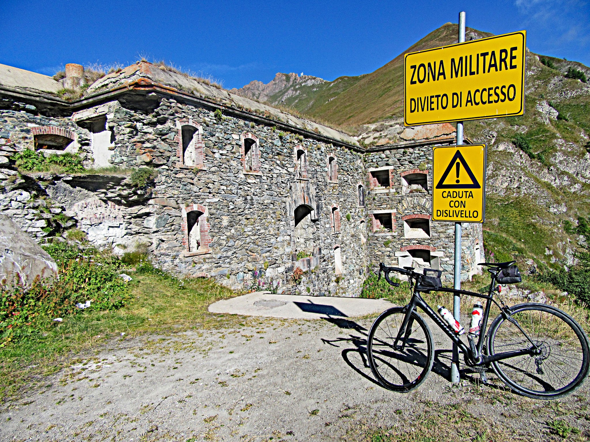 climbing Colle delle Finestre  by bike - military fort, sign, bicycle
