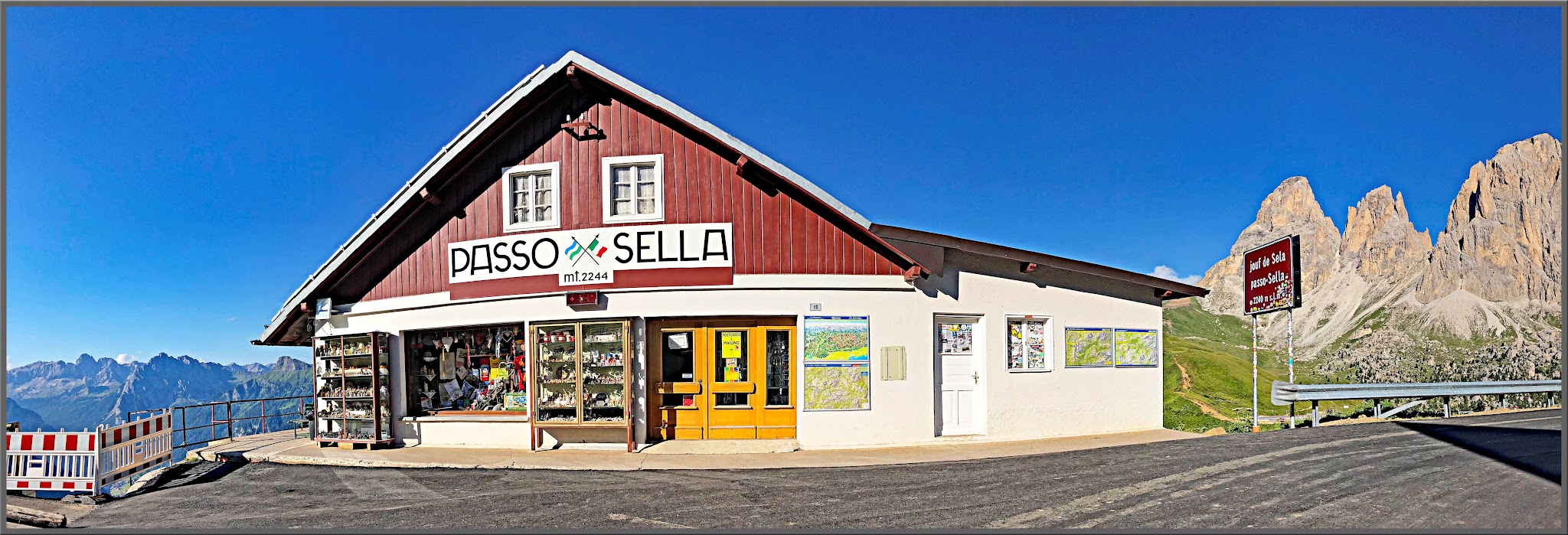 Cycling Passo Sella - large red building with sign for Passo Sella on front