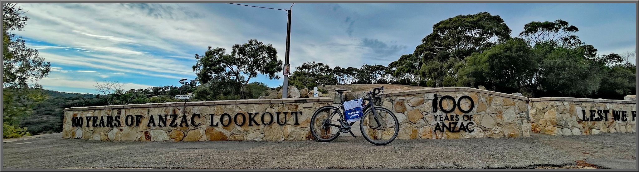 Cycling Kensington Road Lookout, Wattle Park, Australia bike parked against stone wall reading "100 years of Anzac Lookout, 100 years of Anzac"