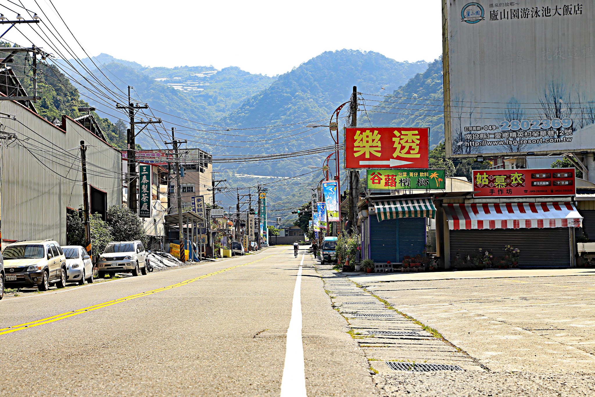Bike climb Wuling Pass West - town, bicyclist on bike on road