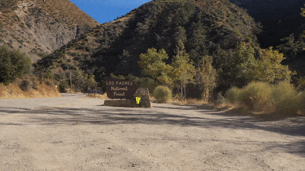 Cycling Highway 33 to Pine Creek Summit - aerial drone footage of NPS Sign for Los Padres National Forest and surrounding hillsides