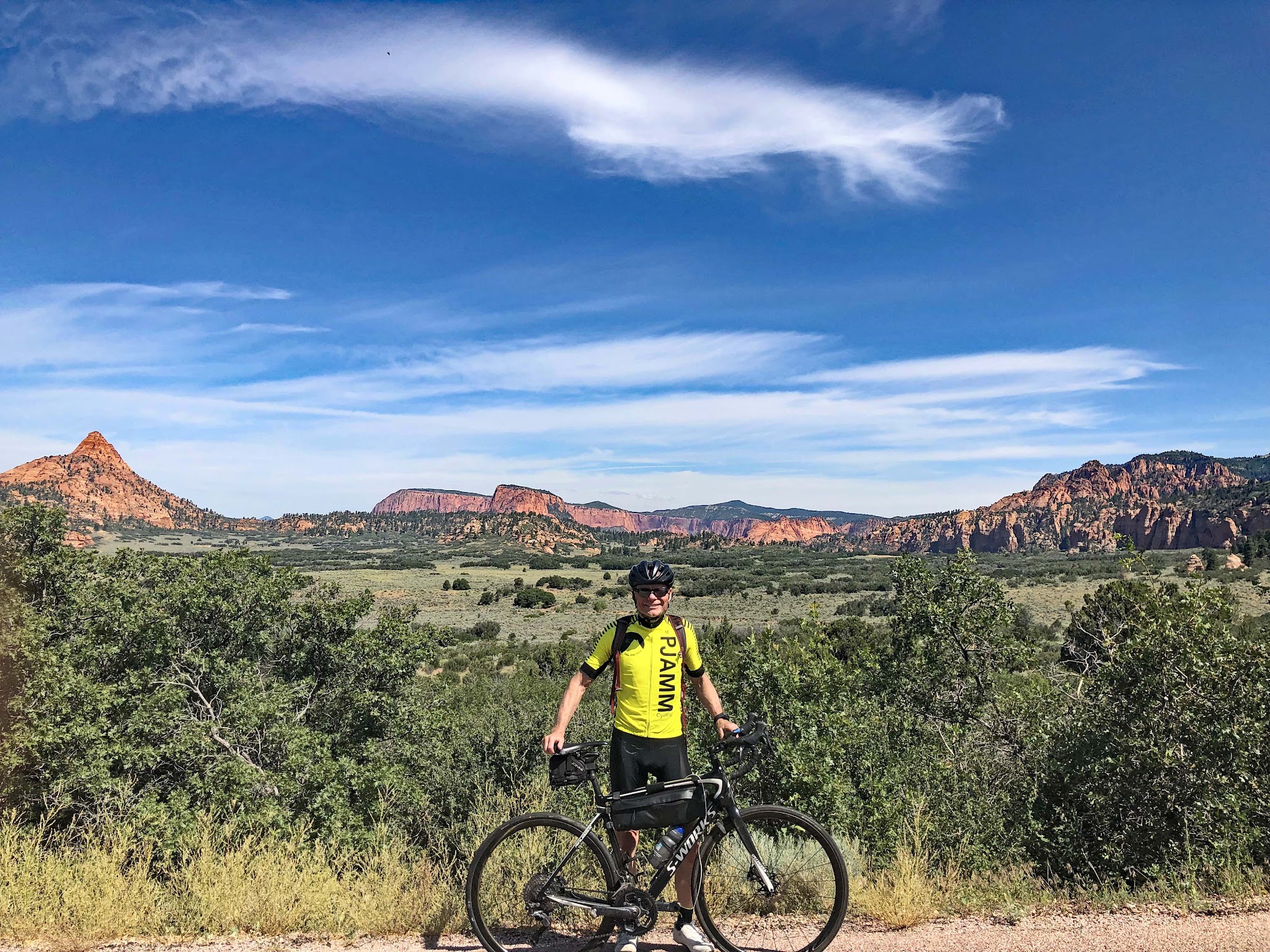 Cycling Kolob Terrace Road - John Johnson PJAMM with bike and rock formations in background