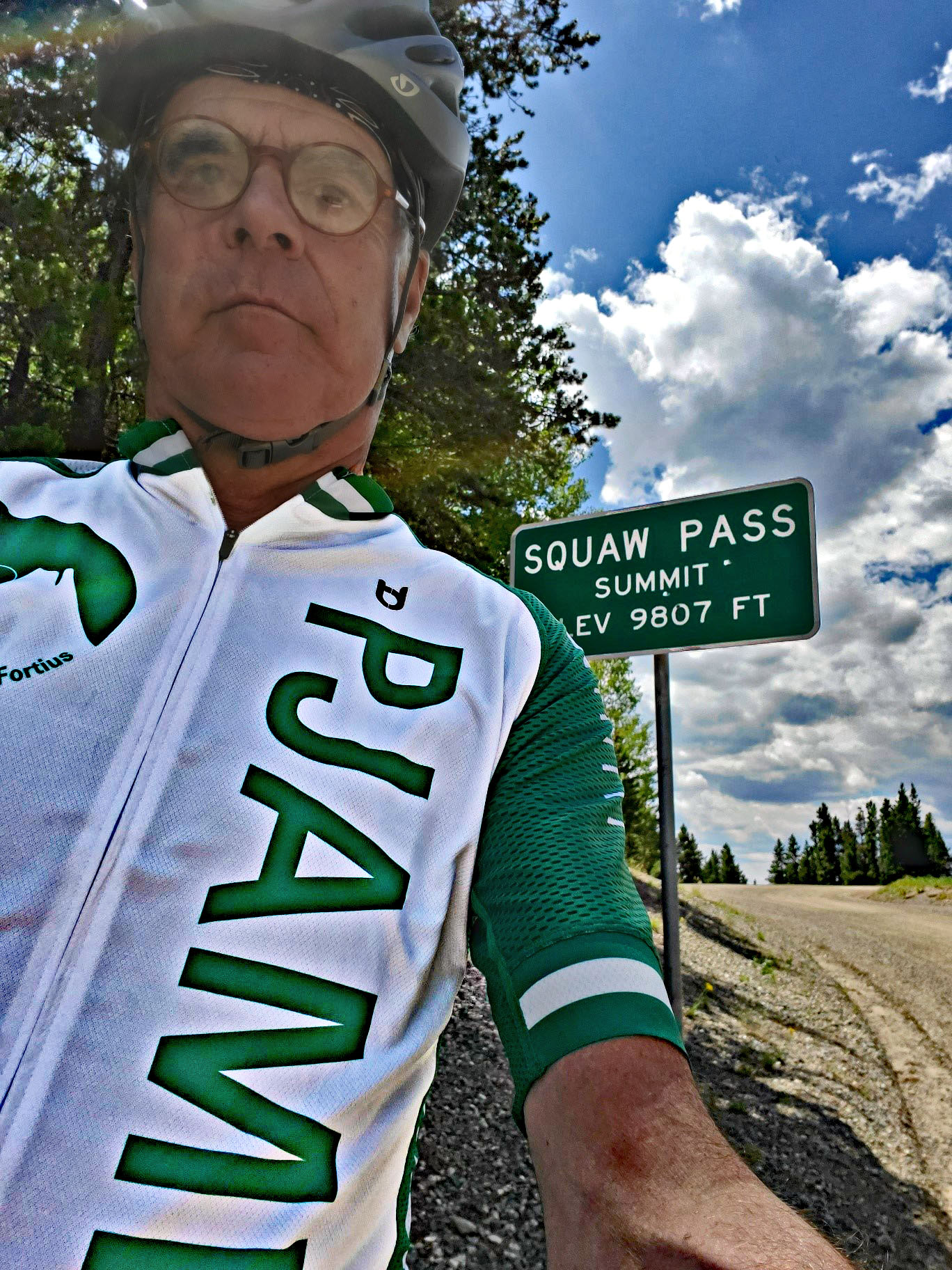 Cycling Juniper Pass West - selfie of cyclist wearing PJAMM Cycling jersey next to road sign for Squaw Pass Summit