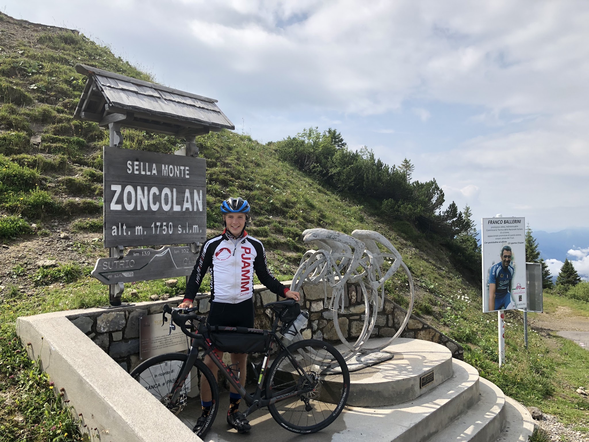 Monte Zoncolan from Ovaro bicycle climb - pjamm cyclist at the pass sign with bike